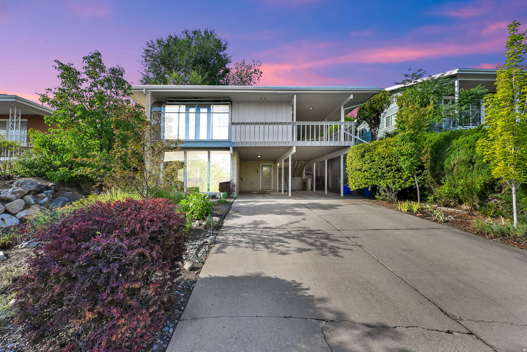 Perched high in the Avenues, this Mid-Century Modern duplex had been thoughtfully renovated with a respect to its original design. Clean lines, open living spaces, a rock entryway, solarium, bamboo flooring, quartz countertops, stainless steel appliances, tiled walls, original floating concrete fireplaces with gas inserts, walls of bookshelves, & contemporary cabinetry. The upstairs unit features a wraparound deck with city and mountain views, a spacious entertaining space, big island bar with pendant lighting, 2 generously sized bedrooms with ample closet space, and a private backyard complete with 2 decks. The downstairs unit walks in at ground level and is filled with natural light thanks to walls of windows that create an open, airy feel. It offers two 2 large bedrooms and access to its own private patio just off the kitchen. Both bathrooms have been renovated with oversized walk-in showers. Significant mechanical and energy-efficient upgrades include solar panels installed in 2018, a membrane roof with additional insulation to prevent standing water on roof, an upstairs furnace replaced in 2023, updated windows, a mini-split system in the lower unit, recessed lighting, and a low maintenance xeriscaped yard. 2 car carport featuring EV charging station and 4 additional parking spaces- a rarity for the Avenues. Owner occupied and meticulously cared for by the same owners for the past 24 years. Ideal for an owner-occupied duplex, a high-quality investment property, or could be converted to a single-family residence (the neighbors across the street did it!). Opportunities like this are rare. With iconic Mid- Century Modern design, extensive upgrades, incredible views, and unmatched versatility, this is a special property.