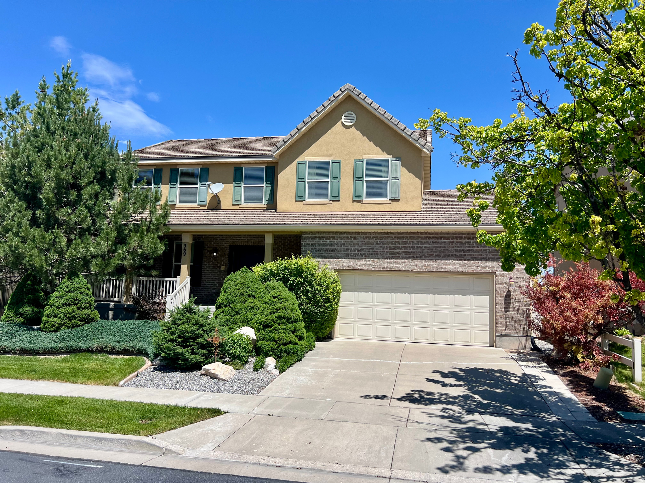 Former model home with timeless charm and exceptional care throughout! This spacious two-story home offers a functional layout with beautiful finishes and room for everyone. The main level features formal living and dining spaces with rich wood flooring, along with an open-concept kitchen, dining, and family room designed for everyday living and entertaining. The kitchen includes granite countertops, tile flooring, and ample cabinetry, while the adjoining family room offers a cozy carpeted gathering space. The fully finished basement expands the living area with an additional family/theatre room wired for surround sound (speakers included), bedroom, office, and a 3/4 bathroom-perfect for guests, work-from-home needs, or multi-generational living. Upstairs you'll find four bedrooms, including an oversized primary suite featuring a spacious walk-in closet, double sinks, and a separate tub and shower. Enjoy relaxing mornings on the inviting rocking chair front porch, and unwind in the beautifully manicured backyard retreat complete with full fencing, mature landscaping, raspberry bushes, and fruit trees. Newly available high speed fiber optic service on this cul-de-sac. The Stansbury Park area offers a golf course, lake activities, community pool, shopping and nearby schools. This lovingly maintained home is in excellent condition and ready for its next owners to make lasting memories.