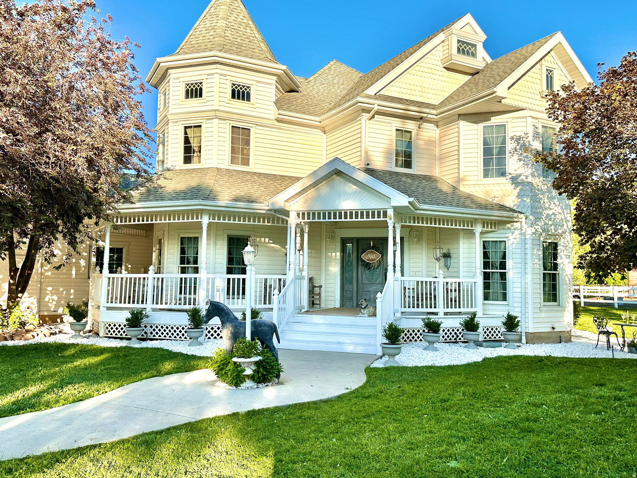 Set within the coveted embrace of Ogden Valley, this living legacy is for the horse lover, the nature lover, the keeper of animals - offering seclusion while still feeling held by community. Pass through the private gate into a gated enclave of fourteen homeowners, connected by a newly paved road (2025) and a terra cotta chip-seal driveway that shifts hue with the sun. At its heart, a Victorian home nestled in the mountains on 12.78 acres, rises beside its own indoor riding arena - the freedom to ride every day of the year, whatever the season brings - backed by a private forest of bluebells in the late Spring, a beaver-made pond, and a year-round creek, home to wildlife such as deer and occasional moose, heron, sandhill crane, wild turkeys, and more.  The 4,378-square-foot home, built in 1997, offers European-influenced elegance across three levels - nine-foot ceilings, oak hardwood floors, floor-to-ceiling windows framing the horses beyond, and a wraparound porch. A grand staircase anchors the main floor's living room, office, dining room, kitchen (Bosch dishwasher, 2025 KitchenAid refrigerator, LG double oven, LG microwave, 2024 water purifier/softener), and family room, piped and vented for a wood-burning stove.  Upstairs, three bedrooms include a primary suite with gas fireplace, a full master bathroom suite with separate shower, clawfoot tub, and a built-in armoire, and a private balcony where, during high-flow months, the creek can be heard from the master balcony. Step into the magnificent turret bedroom, its high ceilings and round walls catching light in every direction, by day and starlit by night. A third bedroom holds its own enchanting private sitting room, a quiet retreat for reading or unwinding as the day winds down. The upper floor also includes a spacious second full bath with a huge soaking tub and separate shower.  The finished lower level offers three bedrooms, currently used as an art studio, a wellness room, and a workout room, along with additional bathrooms, a TV or game room, and a Sunlighten four-person infrared sauna.  For the horse lover: a 75-foot by 150-foot indoor arena, a barn with a 12-foot by 20-foot Priefert foaling stall, a 12-foot by 12-foot companion stall, four 12-foot by 12-foot walk-out stalls, a separate tack room and wash area, plus an attached second two-car garage. On the south end of the property, an additional pasture offers two horse shelters - a tall 16-foot by 60-foot shelter suited for hay storage as well as sheltering, and a 12-foot by 24-foot shelter. The current owners have given their horses free rein of the open pastures, which is why they're grazed close to the earth rather than green and lush - by choice, not by limitation. Future owners could create smaller paddocks for rotational grazing, allowing the remaining pasture to be seeded and watered into lush, green grazing land. A four-car garage with half bath completes the home. Community well water with plenty of shares, HOA-gated road. Minutes to Snowbasin and Pineview Reservoir; 30 minutes to Ogden. Showings are available to qualified buyers with proof of funds or a prequalification letter, and buyer's agents are welcome. Because this is a working horse farm, 48 hours' notice is required, and caretakers will remain on-site during showings. Sale is contingent upon the seller securing a replacement property.