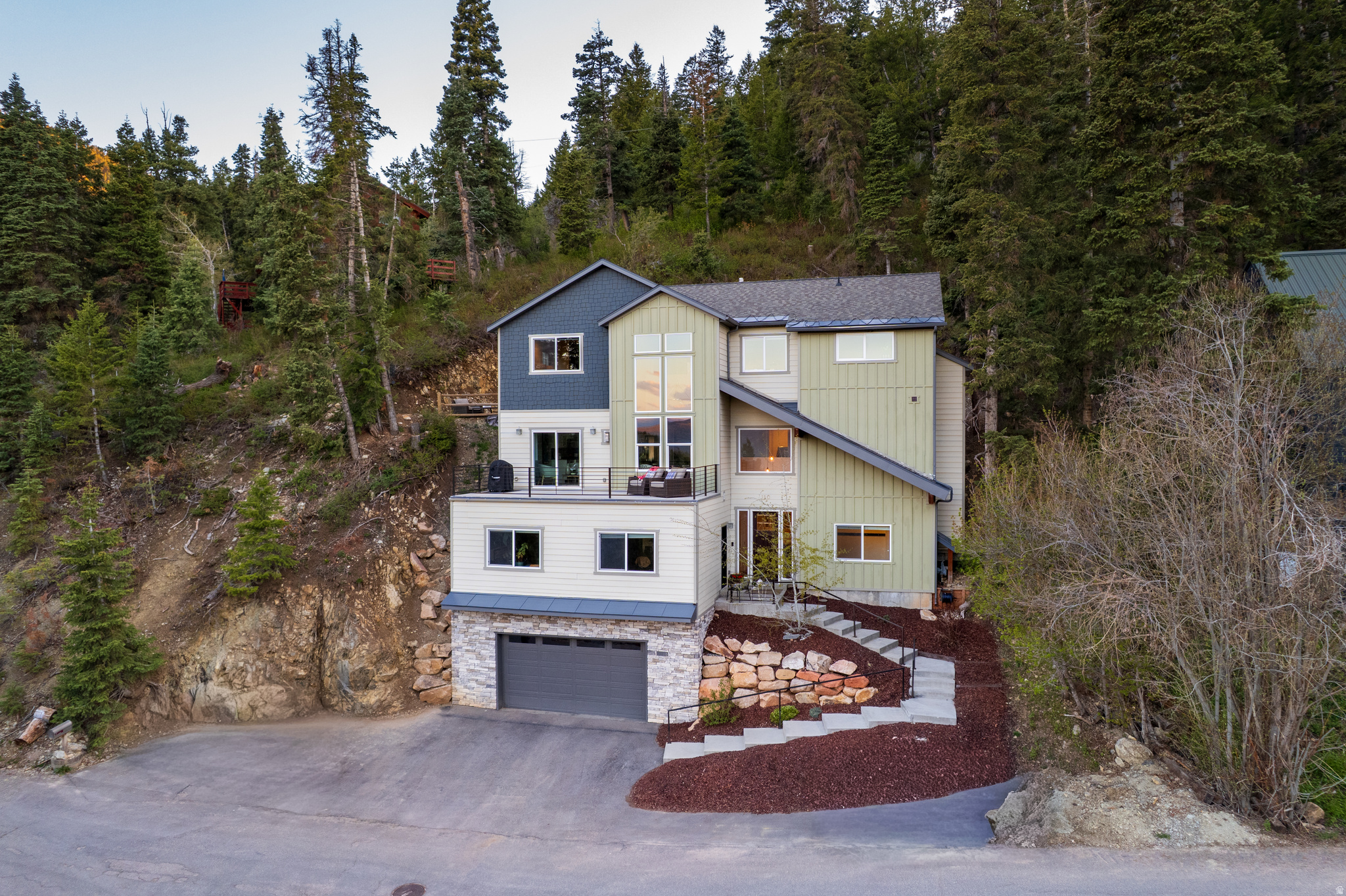 Perched in the trees of Summit Park, this beautifully updated mountain home offers unobstructed views, direct trail access, and the perfect blend of privacy and convenience. Backing to open space and miles of hiking and biking trails, the setting feels secluded, yet you're just minutes from Park City, Salt Lake, and year-round adventure.  Inside, the home has been thoughtfully updated with a fresh, modern feel. The open-concept layout is anchored by tall ceilings and expansive windows that flood the space with natural light while framing the surrounding landscape. The main living areas flow seamlessly, creating an ideal setting for both everyday living and entertaining. The home features an extra-large pantry great for hosting. Generously sized bedrooms provide comfort and flexibility, while multiple living spaces, including a spacious family room--offer room to spread out, work from home, or host guests. Step outside to a beautifully landscaped backyard designed for effortless outdoor living. Backing directly to trails and open space, the private outdoor retreat features a fully functioning outdoor kitchen, fire pit lounge area, comfortable seating spaces, and a large dining area perfect for al fresco entertaining beneath the trees. A sun-filled balcony further extends the living space and showcases the surrounding mountain views.  Additional highlights include a two-car garage, ample storage, and energy-efficient construction. Located on a quiet street just moments from the bus route, this home delivers the best of mountain living with easy access to everything Park City has to offer. Total square footage includes a legal ADU currently generating rental income.