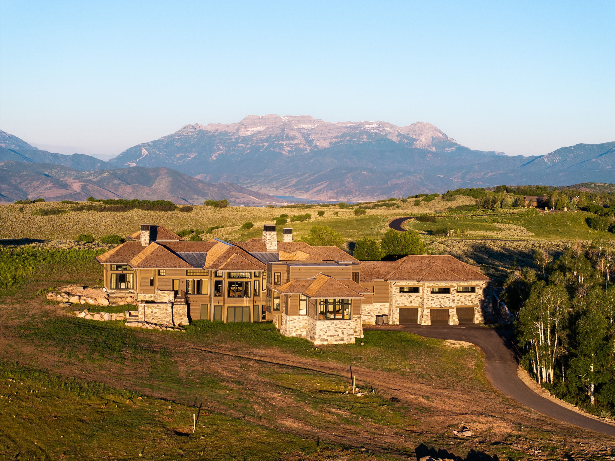 Some homes are built to impress. The rarest are built to endure.  Nestled on 160 private acres in the heart of Wolf Creek Ranch, this extraordinary estate represents a convergence seldom found in modern residential architecture: a remarkable homesite, a celebrated architectural vision, and craftsmanship executed without compromise.  Designed by the renowned firm McAlpine, the residence embraces a philosophy of quiet confidence. Every proportion, every material, and every view has been considered-not to compete with the landscape, but to become part of it.  The approach is deliberate. A winding drive through mature aspen groves gradually reveals the home before opening to sweeping 360-degree views across the Wasatch and Uinta Mountain ranges, anchored by the iconic silhouette of Mount Timpanogos. The sequence feels cinematic, rewarding arrival with a panorama that changes with every season and every shift of mountain light.  Rather than announcing itself through excess, the home speaks through restraint.  Natural stone, timber, steel, and expansive glass create interiors that are warm, tactile, and deeply inviting. Light moves effortlessly through each room, while carefully framed vistas ensure the landscape remains the home's defining work of art. Every space unfolds with intention, creating moments that feel intimate despite the home's remarkable scale.  Architecture of this caliber is measured not by what it adds to the land, but by how naturally it belongs there.  Complementing the home's connection to nature is a private wellness sanctuary thoughtfully designed for restoration and renewal, featuring a luxurious spa and steam room, a fully equipped fitness studio, oxygen lounge, and dedicated meditation room.  Beyond the residence lies one of the American West's most extraordinary private landscapes. One hundred sixty acres unfold in every direction, where private trails, a beautifully appointed yurt, and even your own backcountry ski runs invite year-round adventure without ever leaving the property. Wolf Creek Ranch encompasses more than 13,200 acres of protected wilderness with over 60 miles of maintained trails, private fly fishing on the Upper Provo River, stocked ponds, equestrian amenities, and an outdoor lifestyle that begins at your doorstep rather than miles away.  Designed to embrace every season, the estate also offers two stacked, heated three-car garages, complemented by an additional pull-through garage purpose-built for mountain toys, adventure vehicles, and effortless access to the surrounding landscape.  Today, creating an estate of this significance would require years of land acquisition, architectural design, approvals, construction, and interior execution-all while navigating an increasingly uncertain building environment. Here, that journey has already been completed with uncommon discipline and care.