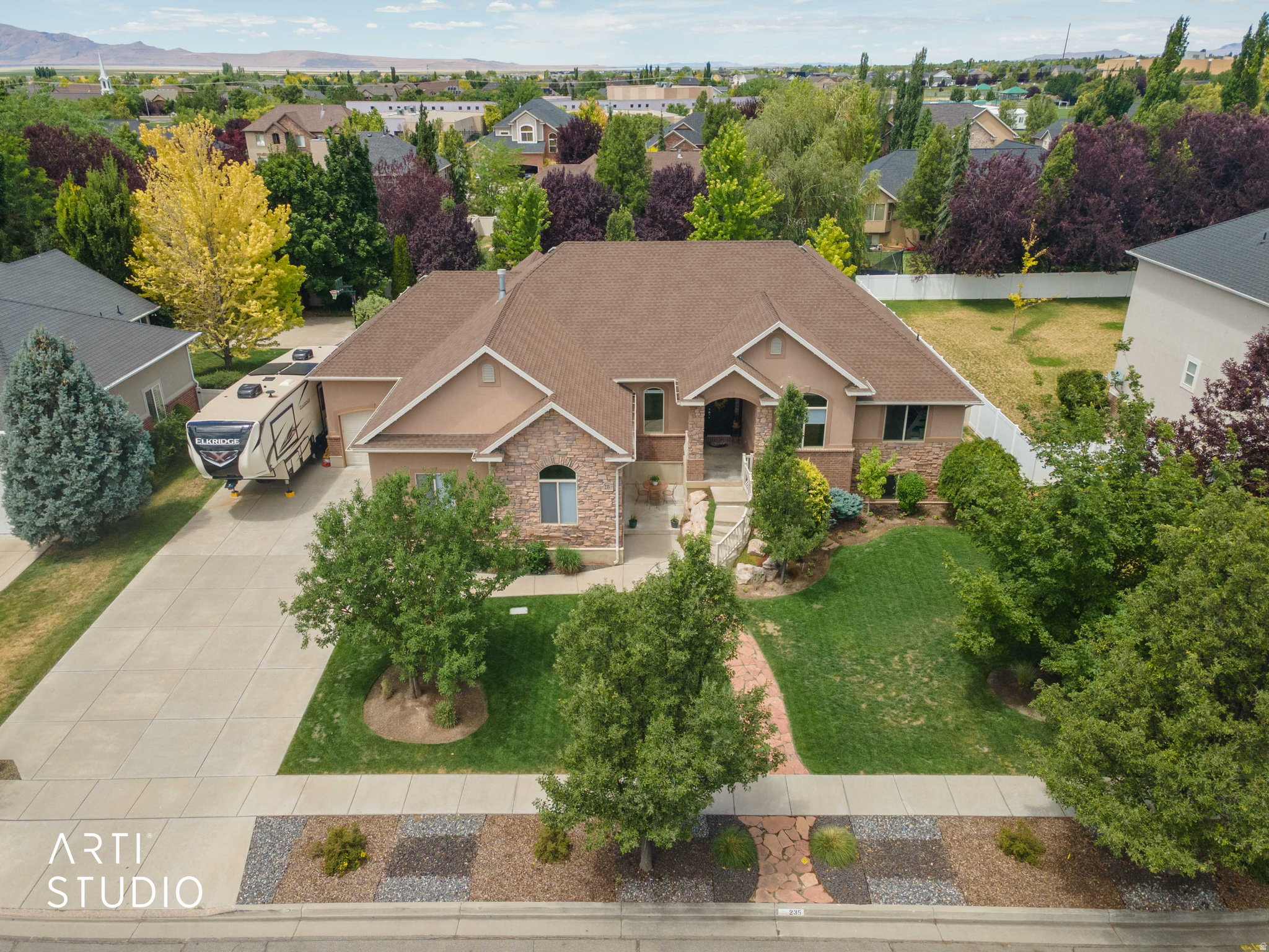 Pride of ownership and an exceptional floor plan combine with an abundance of upgrades to create an effortless lifestyle in this meticulously maintained, quality-constructed home. A welcoming covered front porch opens to an elegant foyer where soaring ceilings, stunning arched entryways, custom trim, and crown moulding create a warm yet sophisticated first impression. The open-concept living room flows seamlessly into the dining area and gourmet kitchen, featuring gleaming stainless steel and built-in appliances, a countertop gas range, two JennAir built-in convection ovens, a spacious corner pantry, and a large center island with a waterfall quartz countertop-perfect for everyday living and entertaining. Step directly onto the expansive covered deck overlooking the large, fully fenced backyard, creating an ideal setting for family gatherings, outdoor dining, and play. Designed with convenience in mind, the thoughtfully planned main level offers comfortable single-level living with a luxurious primary suite featuring a fireplace, a second bedroom, a dedicated office, and a spacious laundry room. The fully finished lower level expands the home's versatility with a generous family room featuring a second fireplace, a wet bar complete with kitchen appliances, and four additional bedrooms. With French doors providing direct access to the backyard and patio, this level is exceptionally well suited for multi-generational living, extended family, long-term guests, or growing households seeking flexible living space. Additional highlights include mature landscaping with shade and privacy trees, a three-car garage, RV parking with a 50-amp hookup, a smart thermostat, Hunter remote-control blinds, two water heaters (2019), and a water softener system. Ideally located in a highly desirable neighborhood near schools, parks, shopping, dining, and everyday amenities, this home also offers convenient access to the West Davis Highway, making commuting to Salt Lake City quick and easy. Combining quality craftsmanship, exceptional space, and flexible living options, this remarkable home is perfectly suited for families of every stage and size.    Square footage figures are provided as a courtesy estimate only and were obtained from county records.  Buyer is advised to obtain an independent measurement.
