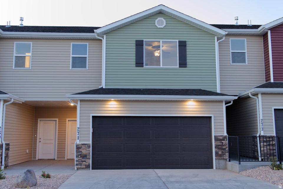Discover this beautifully crafted townhome offering 3 bedrooms and 2.5 modern bathrooms. The attached two-car garage provides plenty of storage space. Inside, the main level features 9-foot ceilings that create an airy, open feel. The living areas are accented with durable luxury vinyl plank flooring, while the bedrooms and upstairs hallways are cozy with plush carpeting. The kitchen is equipped with stainless steel appliances, a gas range, quartz countertops, a stylish subway tile backsplash, and soft-close cabinets. The inviting living room showcases a charming shiplap accent wall and stunning lighting fixtures. The primary suite's bathroom offers his and her sinks for added convenience. Step outside to a fenced backyard and a covered patio, perfect for outdoor entertaining and relaxing.