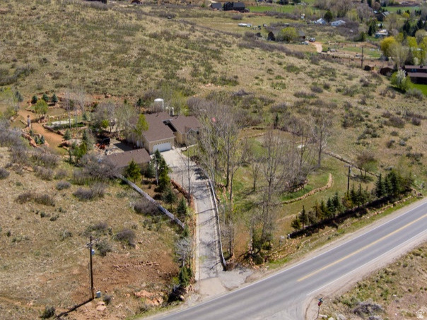 This isn't just a home, it's your own private escape, set against the breathtaking backdrop of Mount Timpanogos. Tucked just outside Heber City on nearly five acres, this property offers a rare blend of serenity and space. Whether you envision a secluded estate or a multi-generational retreat, the possibilities here are as expansive as the land itself. Step inside and you're immediately greeted by soaring ceilings and walls of windows that flood the home with natural light, creating an airy, welcoming feel throughout. The open concept layout is designed for both everyday living and effortless entertaining, with seamless flow from room to room. Upstairs, two additional bedrooms and a  bath provide comfort and privacy. The main floor offers main floor living with a primary suite with ensuite bath for main floor living. Downstairs, the fully equipped lower level opens the door to even more flexibility. With its own entrance, space for a second kitchen, two bedrooms, and a full bath, it's perfectly suited for a mother-in-law suite, and guest quarters. Outside is where this property truly shines. An expansive tiered deck invites you to unwind or entertain while taking in sweeping mountain views. Beautifully crafted rock retaining walls create a sense of privacy and elevate the landscape, turning the outdoor space into a peaceful sanctuary. With two water shares from Lake Creek Irrigation and major updates already complete including a new roof (2023), water heaters (2024), and furnace & A/C (2018) this home is ready for its next chapter. Private. Versatile. Unforgettable. Come experience the lifestyle this property offers, schedule your private tour today. Buyer/Buyer's agent to verify all info. Agents related to seller.