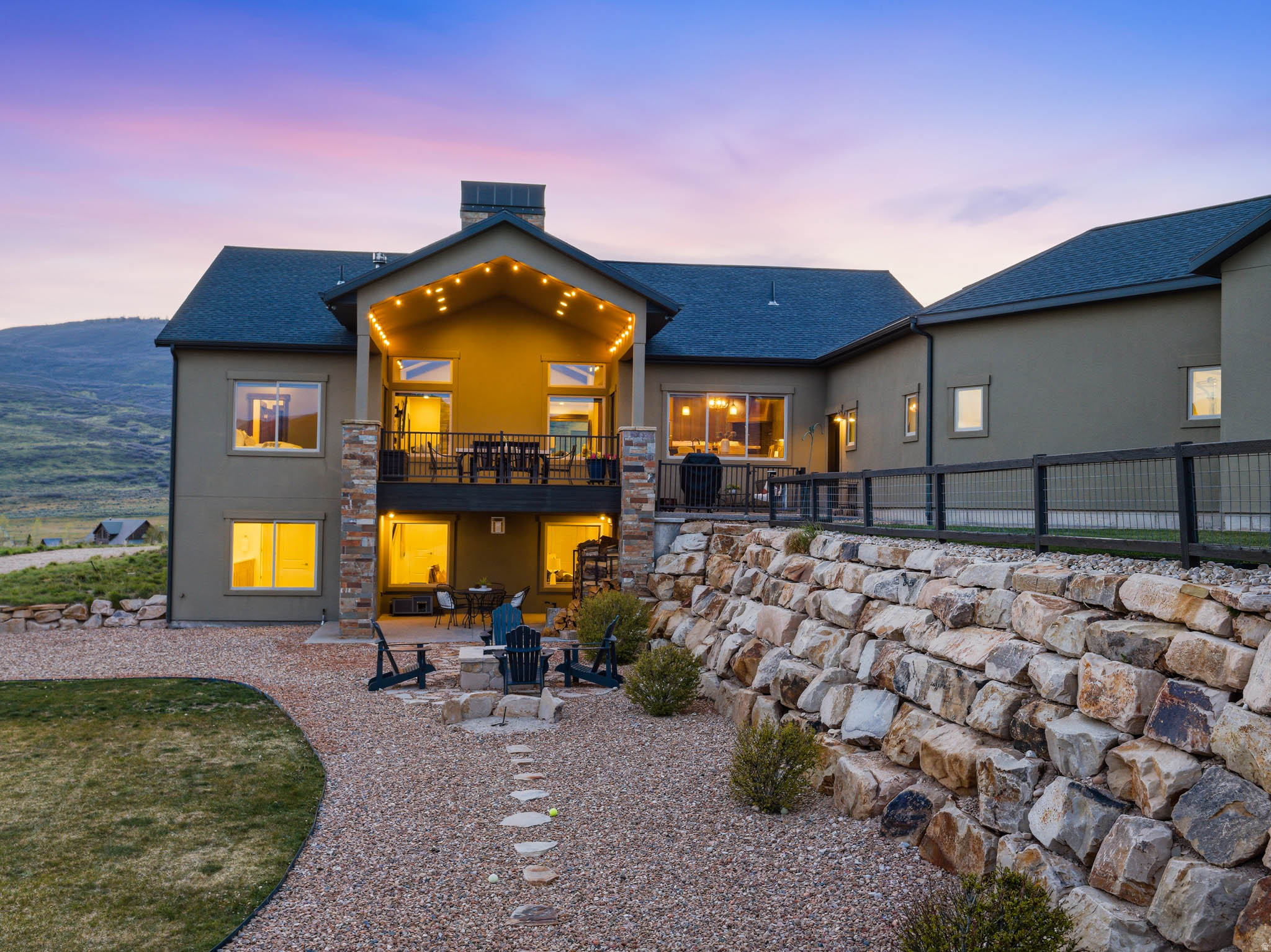 OPEN HOUSE - SATURDAY, JUNE 6TH 1:00 - 3:00 PM.  * Call 801-699-8781 for gate access*  Located within Sunrise Ridge, a gated community of custom homes. This residence offers a refined blend of craftsmanship, privacy, and elevated mountain living, set against sweeping views of the surrounding valley. Just 30 minutes from Salt Lake City and 15 minutes to Park City, with close proximity to the Echo and Rockport Reservoirs and the Weber River, the location balances accessibility with a true sense of retreat. Built by Big Canyon Custom Homes (this was the owner's personal home), a luxury boutique builder, this home reflects a level of architectural intention and quality construction that discerning buyers will appreciate, with thoughtfully selected materials and a strong connection to the surrounding landscape.  The main level is designed for effortless, single-level living and flows naturally to an expansive covered deck. Wide plank, rough-sawn oak wood floors span the living spaces, adding warmth and texture, while generous windows frame the views and fill the home with natural light. A striking stone fireplace anchors the great room, creating a sense of understated sophistication. The kitchen is both functional and beautifully finished, featuring rich leathered granite, Thermador range, stunning copper-accented range hood and island details. Heated tile floors in the bathrooms add a subtle, luxurious layer of comfort. The lower level extends the home's livability with two additional bedrooms, two full baths, large storage areas, along with a well-appointed bar and kitchenette. A spacious media and game area opens to a walkout patio featuring a large custom firepit with a hardwired gas line. The pool table and wall-mounted TVs are included, creating a turnkey entertainment space. Both the patio and covered deck are equipped with gas hookups for BBQs, allowing for seamless indoor-outdoor living.  The tiered backyard adds both charm and function with a horseshoe pit, a dedicated garden area, and inviting spaces for gathering or relaxing.  An oversized heated four-car garage and dedicated RV parking provide exceptional utility, thoughtfully integrated into the overall design. This is a rare opportunity to own a custom home where craftsmanship, setting, and lifestyle align--with space to breathe, views to enjoy, and a location that keeps everything within reach while still feeling a world away. Ideal as a primary residence or second home!