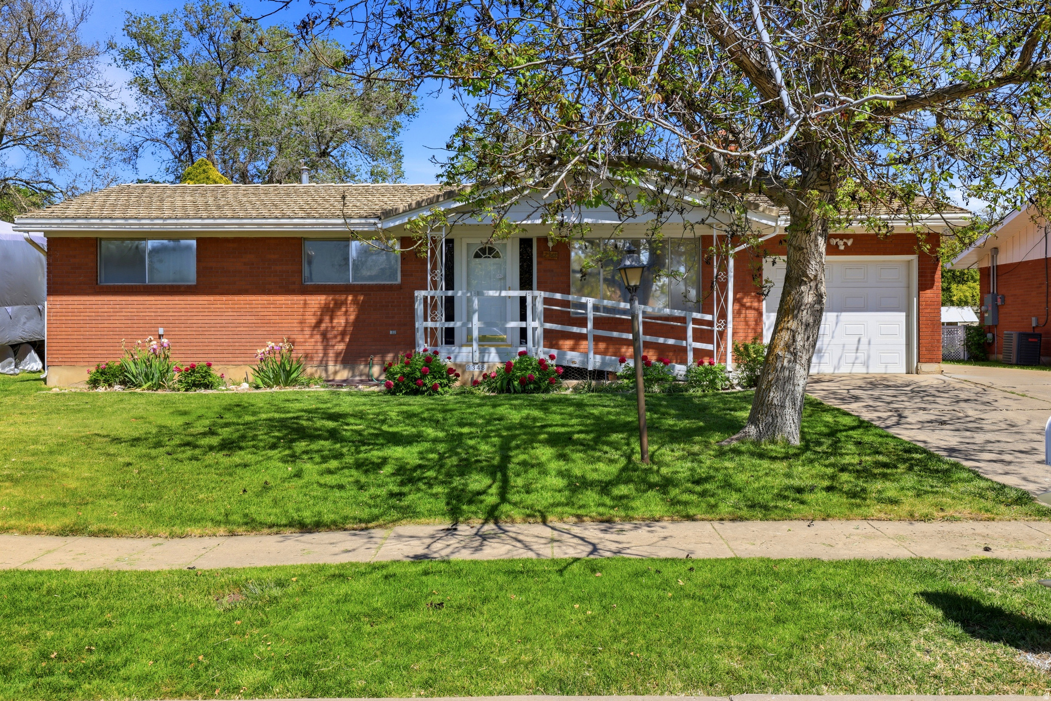Welcome to this classic brick rambler-style home featuring 4 bedrooms and 2 bathrooms. You'll enjoy the spacious front living room with a cozy fireplace and great views of the large backyard from the kitchen. Escape to the basement family room, which offers additional space to relax and entertain.   The brick exterior, tile roof with a 75 year warranty, fully landscaped yard, and automatic sprinklers provide easy, low-maintenance living. The garage, extra driveway space, and large shed offer plenty of room for vehicles, storage, and toys. Conveniently located near schools, shopping, dining, and other amenities, with quick access to I-15 for an easy commute. Don't miss it!