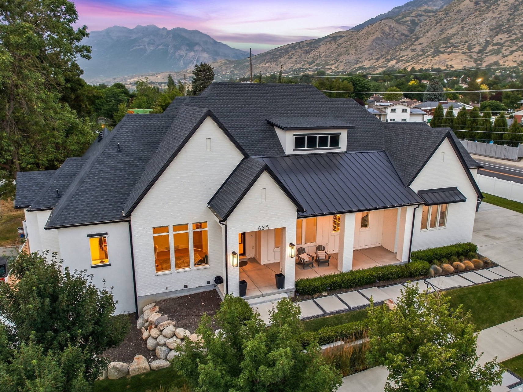 Exceptional craftsmanship and thoughtful design define this remarkable custom home in one of Provo's most sought-after neighborhoods. Originally built as the builder's personal residence, this home showcases premium finishes, meticulous attention to detail, and an ideal layout for both everyday living and entertaining. The stunning great room features soaring 14-foot ceilings, expansive windows, and beautiful white oak wide-plank hardwood flooring that creates a bright, open atmosphere. The gourmet kitchen is a chef's dream, offering custom cabinetry, professional-grade appliances, three ovens, a butler's pantry, and elegant gold-tone lighting. Just off the kitchen, the covered patio features built-in heaters and breathtaking views of Mount Timpanogos, creating the perfect space for year-round outdoor dining and entertaining. The walkout lower level was designed with entertaining in mind, featuring 10-foot ceilings, a spacious gathering area, custom cabinetry, designer lighting, and accordion glass doors that open seamlessly to an incredible outdoor living space complete with a summer kitchen, built-in seating, fire pit, and BBQ. Every bedroom is a private suite with its own ensuite bathroom, providing comfort and privacy for family and guests alike. The oversized garages feature extra height and depth, along with electric vehicle charging capabilities. Professionally designed landscaping, mature trees, outdoor lighting, and a whole-home surround sound system complete this exceptional property. Ideally located within walking distance of BYU, Timpview High School, Centennial Middle School, and Rock Canyon Elementary, this home also offers quick access to Rock Canyon, Provo Canyon, the Bonneville Shoreline Trail, and endless opportunities for hiking, biking, and outdoor recreation. Enjoy nearby shopping, dining, parks, golf courses, and all that Provo has to offer while taking in the beauty of Utah Valley and Mount Timpanogos. This is a rare opportunity to own a truly one-of-a-kind home where exceptional quality, luxury, and location come together.  Square footage figures are provided as a courtesy estimate only and were obtained from county records.  Buyer is advised to obtain an independent measurement.