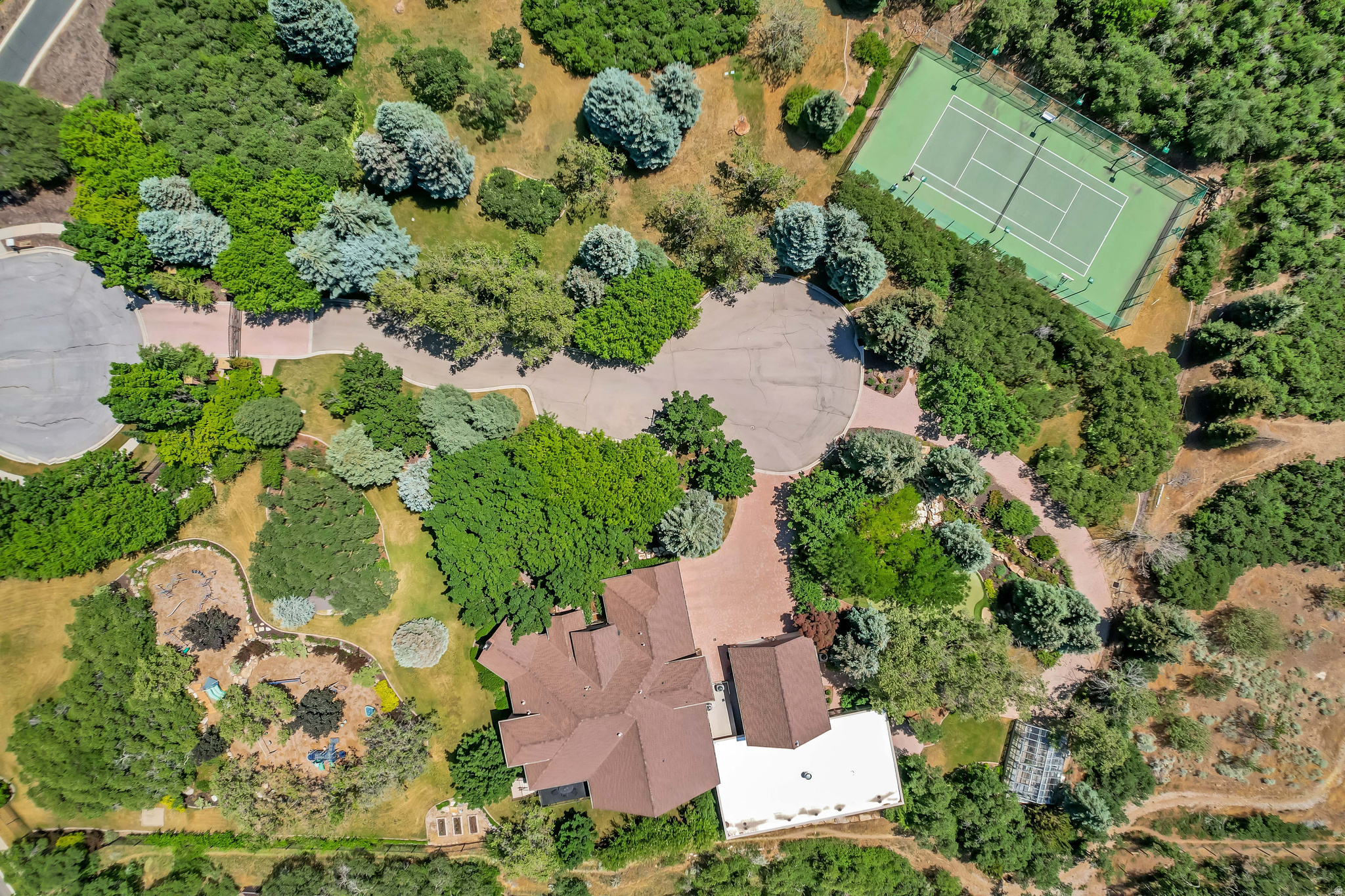 Nestled in the prestigious Holly View Acres, this 7.58-acre estate offers an extraordinary combination of luxury, privacy, and investment potential. Situated on a quiet cul-de-sac, the property is fully gated and fenced, ensuring peace of mind while embracing breathtaking 360-degree mountain views. With four total parcels, this estate presents a rare opportunity to develop, expand, or create a private retreat that backs directly up to US Forest Service Land, preserving privacy and views. The formal living room makes a dramatic first impression, featuring a vaulted ceiling, exposed wood beams, and a luxurious fireplace that serves as the focal point of the space. Expansive windows allow for abundant natural light, highlighting the warmth and elegance of the room. Just beyond, the kitchen is designed for both functionality and entertaining, featuring double wall ovens, a built-in countertop gas range, and a semi-formal dining space. A formal dining room sits adjacent, offering the perfect setting for hosting and entertaining. At the heart of the home, the Great Room boasts a soaring vaulted ceiling, and seamlessly connects to the balcony deck, creating an effortless indoor-outdoor living experience. Enjoy single level living with the Primary Suite on the Main Level, providing a luxurious retreat complete with an oversized shower, jetted soaker tub, and a connecting den with built-in hardwood shelving and workspace for work or relaxation. With 7 bedrooms and 6.5 bathrooms, this home offers abundant space for family and guests alike. Laundry rooms on every level add convenience to daily living, ensuring ease and efficiency throughout the home. The walkout basement is designed for versatility, featuring a full kitchen, designated dining area, and family room with its own separate entrance, making it an ideal mother-in-law apartment, guest suite, or private retreat. The basement is also host to a theater room with stadium seating, making family nights & entertainment at home a breeze. A dedicated wellness and recreation prep area within the basement includes a separate bathroom, shower, Finlandia Sauna, and a Suitmate Swimsuit Water Extractor, ensuring a spa-like retreat after a swim or workout. The indoor heated pool and spa is housed separately from the main residence yet remains easily accessible through the basement entrance. Designed for year- round enjoyment, this space features sliding glass doors around the structure, allowing for an open-air experience when the weather is nice. The surrounding area provides ample room for games, activities, and hosting, making it an entertainer's dream. Stepping outside, the backyard is a paradise for recreation and relaxation, featuring play gyms and equipment for kids, a putting green, a tennis court, and a large greenhouse for homesteading. Whether enjoying outdoor activities or simply taking in the breathtaking scenery, this estate offers an unmatched setting for enjoying the great outdoors. With a stunning paver driveway and oversized 3-car garage with plenty of room for vehicles, toys, and storage, this Estate truly is the perfect blend of practicality and luxury. With its prime location, expansive acreage, and endless amenities, this estate is a rare find in Alpine. Don't miss the opportunity to experience this one-of-a-kind property. Schedule a private tour today! Buyer/Buyer's Agent to verify all.