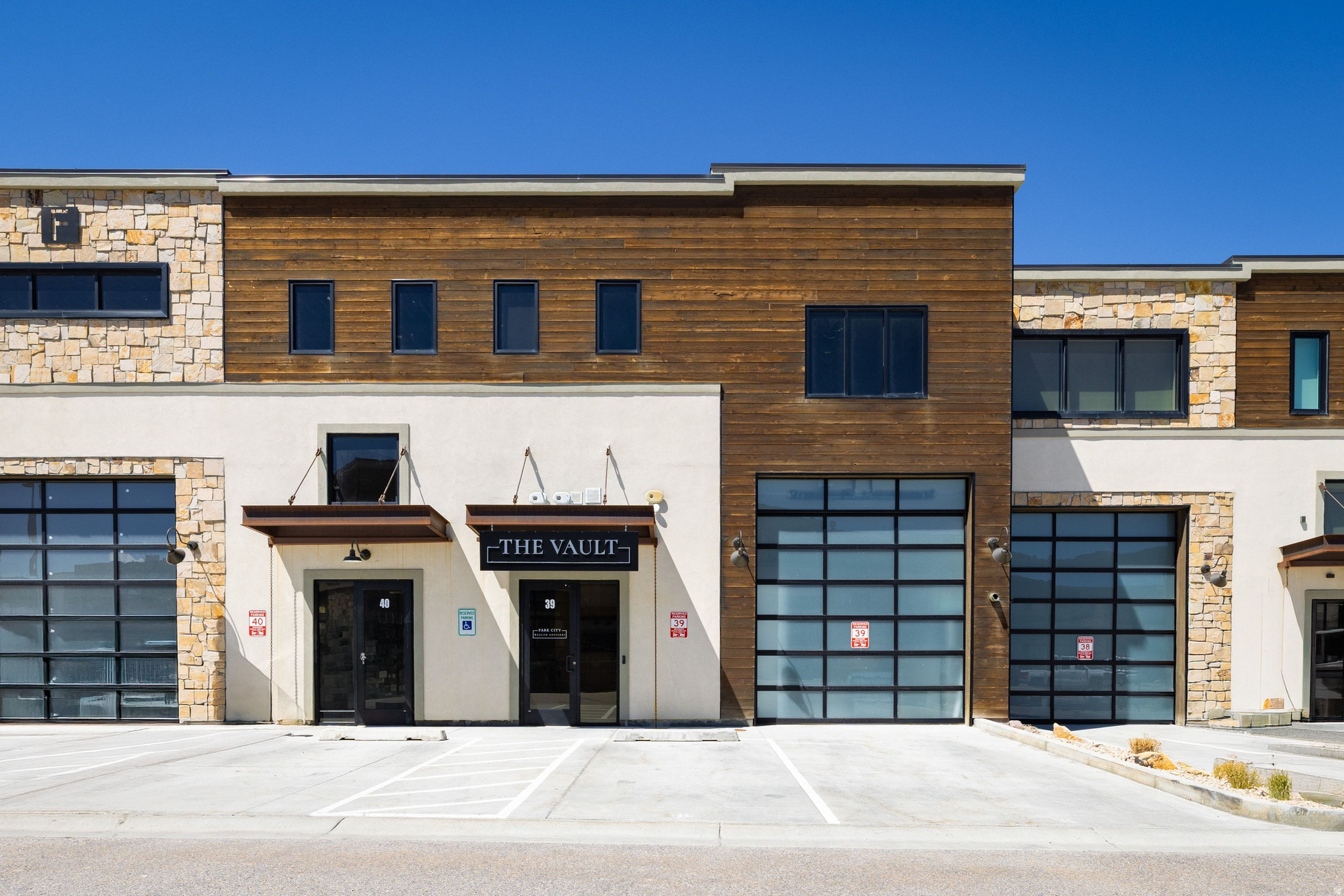 Experience one of the premier finished flex space opportunities within the development at 4554 N Forestdale Drive #F39. Originally designed and built by renowned Alder & Tweed Interior Design, this approximately 3,600-square-foot luxury flex unit seamlessly blends warehouse functionality with elevated showroom-quality finishes rarely found in today's market.  What truly sets this offering apart is the Seller's willingness to execute a leaseback above current comparable lease rates, creating a compelling investor opportunity with projected cap rates exceeding 5%. For buyers seeking immediate cash flow combined with long-term appreciation potential, this property delivers a rare combination of income, flexibility, and premium design.  The main level features a 14-foot oversized garage door, warehouse/storage space, finished offices, a designer bathroom, and an impressive conference room ideal for client meetings and team collaboration. Upstairs, the space transforms into a true showpiece with luxury showroom-level finishes currently utilized as executive office space. The upper level includes a statement kitchen with top-tier appliances and custom finishes, three spacious office or bedroom areas, and two additional private rooms ideal for confidential meetings, podcasting, calls, or executive workspaces.  A significant portion of the property's value is tied directly to the extensive custom built-ins and high-end improvements installed by Alder & Tweed creating a level of finish, functionality, and design sophistication that would be exceptionally costly to replicate today.  Ideal for investors, business owners, creative firms, automotive enthusiasts, or buyers seeking a premium live/work-style environment within the Park City market.