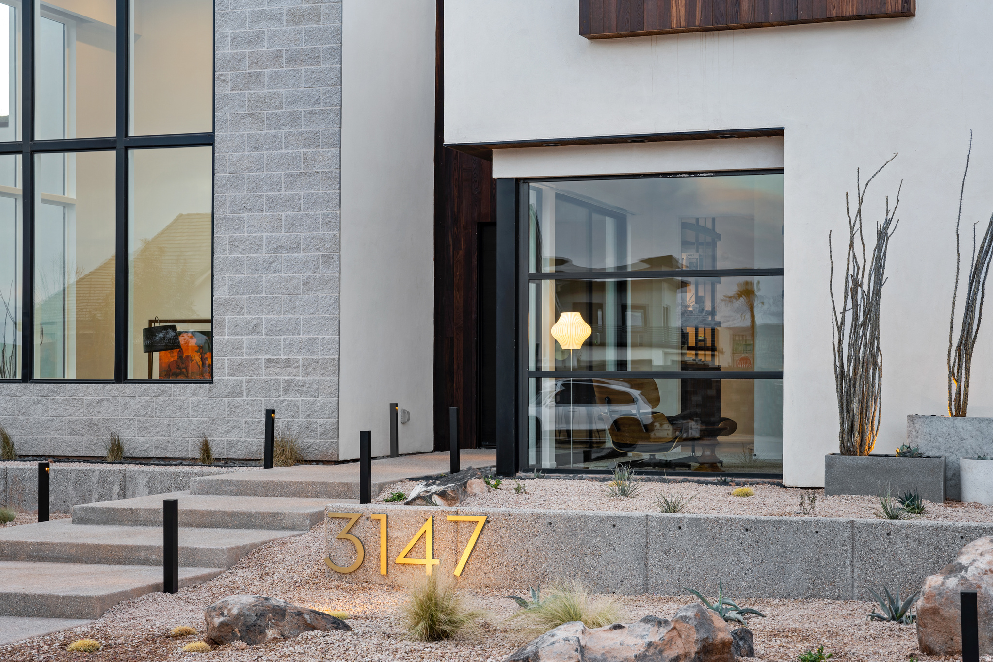 Desert luxury meets effortless living in this striking custom home, where mid-century design and Scandinavian warmth come together in perfect balance. Tucked at the end of a quiet cul-de-sac on a private .35-acre lot, this former Parade Home backs to a serene hillside and is just moments from Copper Rock Golf Course and Sand Hollow reservoir, offering the best of Southern Utah's outdoor lifestyle right at your doorstep. Inside, walls of glass and soaring 22' ceilings create a light-filled great room designed for gathering. The kitchen is both functional and beautiful, featuring warm walnut accents, premium appliances, and a custom banquette perfect for slow mornings or hosting friends. The layout flows effortlessly from intimate spaces to entertaining areas, including a full bar, theater, and music room. The upper level is thoughtfully designed for both privacy and connection, highlighted by a tranquil primary suite with a Japanese soaking tub, and private deck...your own personal retreat. Outside, the experience continues with resort-style living: a custom pool with integrated spa, fire feature, in-water seating, and a climbing wall, plus a rooftop deck ideal for sunset views. Whether you're entertaining or unwinding, every space is designed to elevate everyday living. A private casita complete with its own kitchenette offers flexibility for guests or extended stays, while an expansive garage with 4 RV bays and curated designer finishes throughout complete this exceptional desert escape.