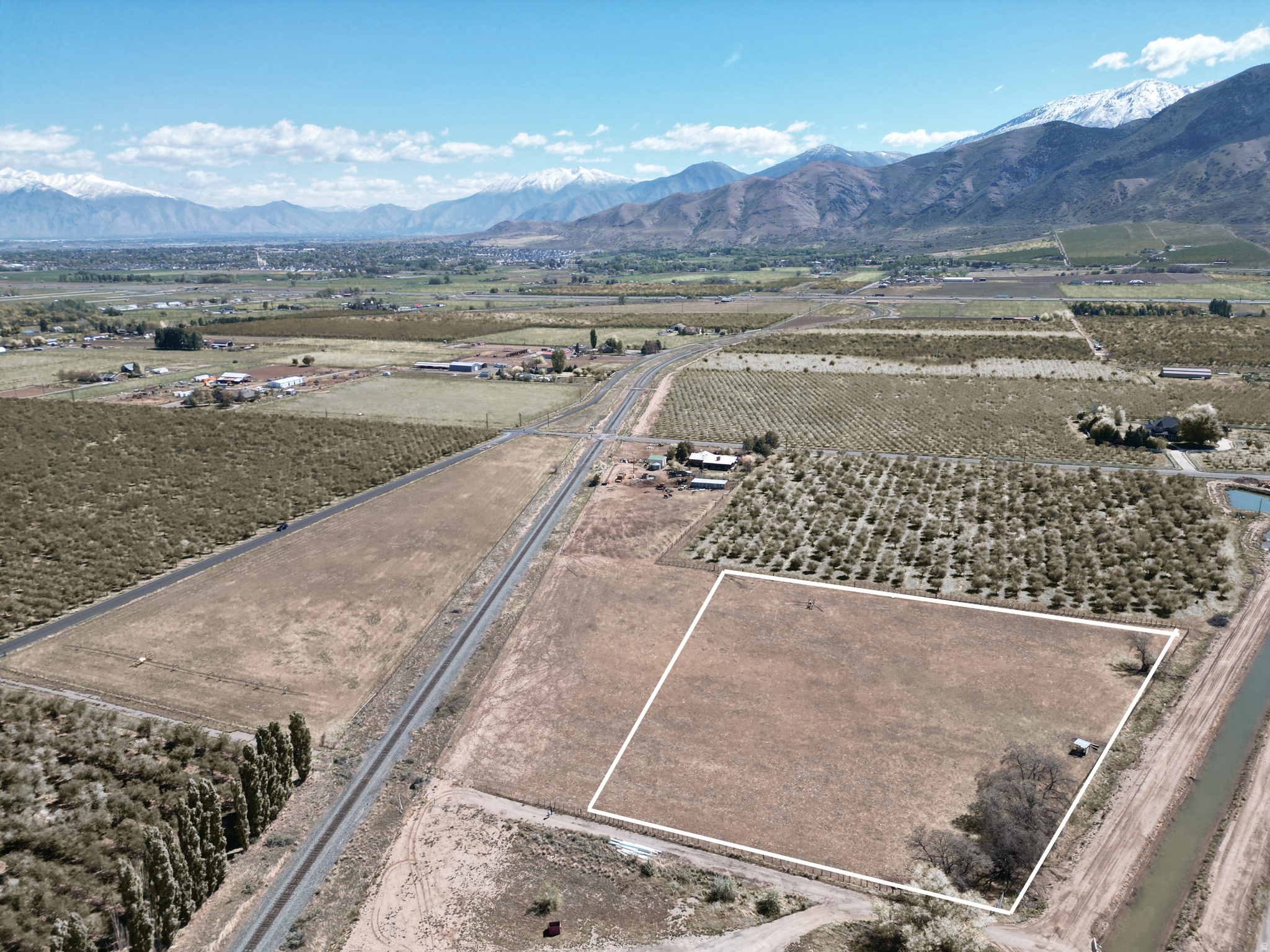 This 3.06-acre residential agricultural parcel offers a great opportunity for those seeking usable land with scenic surroundings. The property includes 6.12 water shares and features pressurized irrigation, making it well-suited for agricultural use or continued livestock grazing. Partially fenced and currently used for cattle, the land is both functional and versatile. Enjoy beautiful mountain and valley views, with the added benefit of being located adjacent to established orchards and a newer development-providing a blend of rural charm and nearby growth.
