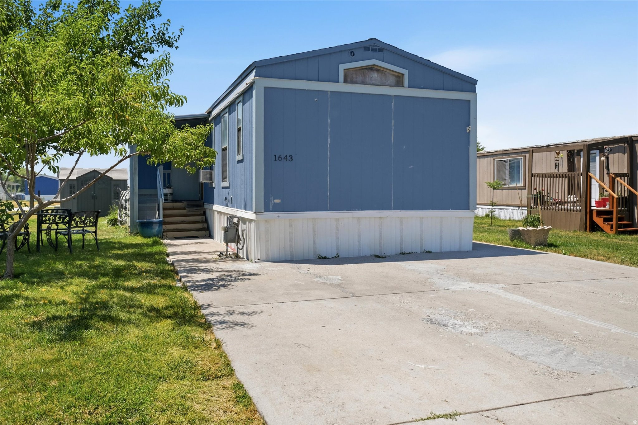 Affordable single-level living! This 2-bed, 2-bath mobile home features a versatile bonus space off the kitchen/living area-perfect for an office or guest bed. Includes 938 sq ft, a covered deck, and full landscaping. Park approval required.