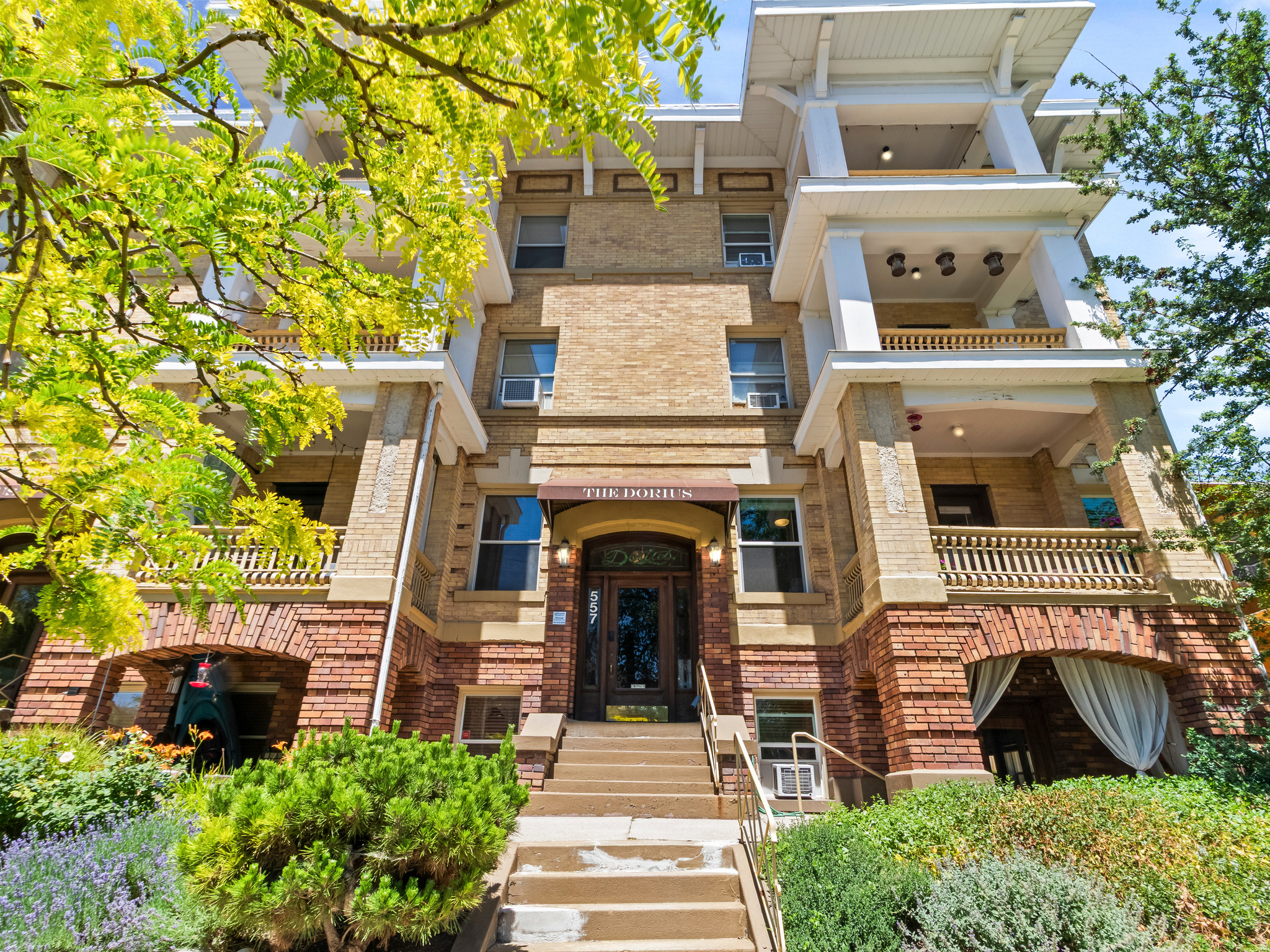 Welcome to Unit 10 at the Dorius - one of the most iconic buildings in Salt Lake City's beloved Avenues neighborhood. Built in the early 1900s, this historic gem delivers the character, craftsmanship, and soul that simply can't be replicated in new construction. Original hardwood floors, exposed brick, and crown molding set the tone throughout. The spacious living room is anchored by a dramatic floor-to-ceiling brick fireplace and opens to a private covered balcony - your perfect perch for morning coffee or soaking in the Avenues. The dining room stuns with a bay window, soaring ceilings, and a statement chandelier that bridges the home's historic bones with modern style. The updated kitchen features knotty pine cabinetry, white quartz countertops, subway tile backsplash, stainless gas range, and dishwasher - all wrapped in gorgeous exposed brick. The primary bedroom is a serene retreat bathed in natural light. The updated full bath impresses with its charming vintage tilework. The second bedroom shines as a guest room, home office, or creative studio with its own dramatic exposed brick wall. Come see it for yourself. You won't want to leave. Square footage figures are provided as a courtesy estimate only. Buyer is advised to obtain an independent measurement.