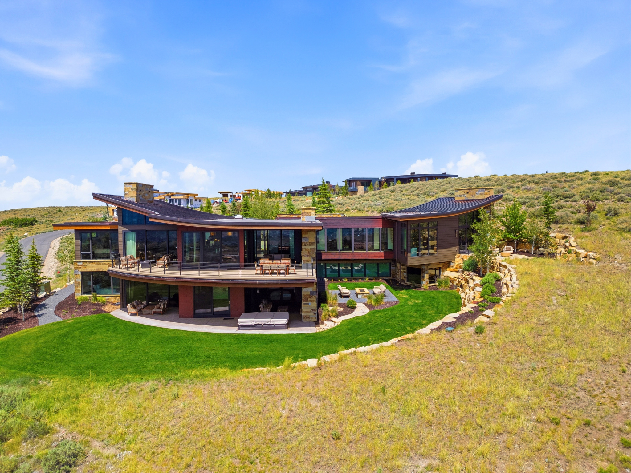 Perched at the very top of Promontory Club, this 9,300-square-foot architectural estate, designed by Michael Upwall and built by Knight Construction, captures panoramic ski-run views from Deer Valley through Utah Olympic Park. Refurnished within the last two years, it is a rare, ready-to-go offering in Park City's premier private mountain community.  Walls of glass and soaring, sculptural ceilings open to the surrounding peaks, while warm stone, wood, and steel create an atmosphere both dramatic and inviting. The main level centers on a double-island kitchen with professional-grade appliances, flowing to elegant living and dining spaces and expansive heated decks and patios for seamless indoor-outdoor living.  Five luxurious ensuite bedrooms offer privacy for family and guests, anchored by a serene primary retreat accessed through an all-glass breezeway, with a spa-inspired bath and walk-through closet. Completing the bedrooms is a custom-designed six-queen bunk room with dual baths, ideal for children and grandchildren. A dedicated office, a 580-bottle climate-controlled wine cellar, glass-walled fitness studio, Swedish sauna, and a ten-person hot tub complete a home built for year-round mountain living. Refined comforts include a home oxygenation system for high-altitude ease and a heated driveway and garage for effortless winters.  Set on 2.36 private acres, the residence offers ski and golf just beyond the door, minutes from Park City's Main Street and Deer Valley and roughly 40 minutes from Salt Lake City International Airport. A Full Golf Membership to Promontory is available through separate transaction, unlocking three golf courses, private ski lodges at Deer Valley and Park City Mountain, a new world-class spa, clubhouses and dining, a beach club, equestrian center, a full calendar of member events, and much more.  Offered fully furnished and impeccably appointed, 3364 Scenic Grade is a rare opportunity to own one of Park City's finest mountain estates.