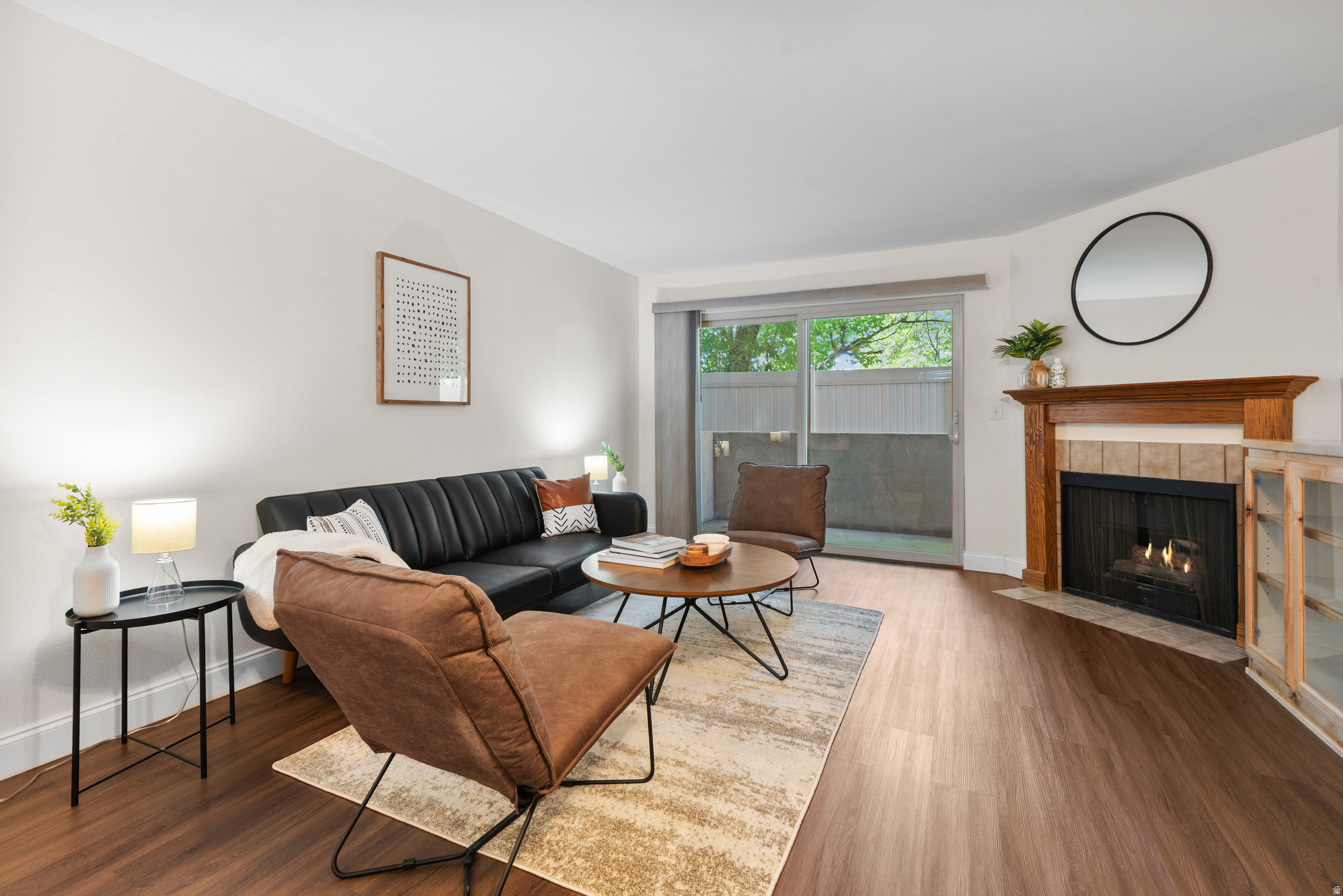 Welcome Home! If location and low-maintenance living are at the top of your list, this FHA-approved main-floor condo is a must-see! Quietly situated toward the back of the community, this inviting home offers 2 spacious bedrooms, each featuring walk-in closets and large windows that fill the space with natural light. The versatile second bedroom includes a built-in bookcase and Murphy bed, allowing it to effortlessly function as a guest room, home office, or both. Durable luxury vinyl plank flooring extends throughout the living areas and bedrooms, providing both style and easy maintenance. Energy-efficient updated windows and a sliding glass door help keep utility costs down year-round. The kitchen is beautifully appointed with rich wood cabinetry, granite countertops, tile backsplash, and stainless steel appliances, including a premium refrigerator. The cozy gas fireplace serves as the centerpiece of the living room, creating a warm and inviting atmosphere. Step outside to your private, shaded patio overlooking mature trees and green space-an ideal retreat for relaxing or entertaining. Additional conveniences include a dedicated covered parking space and ample guest parking. Residents enjoy an impressive array of community amenities, including a swimming pool, hot tub, clubhouse, fitness center, tennis and sports courts, and expansive green space. Even better, the HOA covers most utilities. Located just minutes from major freeways, public transportation, shopping, grocery stores, and numerous dining options, you'll enjoy unparalleled convenience with many everyday necessities within walking distance. Don't miss this opportunity to own a comfortable, well-maintained home in an exceptional location!