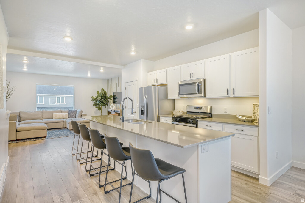 Located in the desirable Northshore community in Saratoga Springs, this mid-row townhouse offers a well-designed layout, functional living spaces, and access to a variety of neighborhood amenities including a park, two swimming pools, and a clubhouse, all maintained by a well-managed HOA.  The entry level includes a two-car garage, a full bathroom, and a versatile bedroom that can be used as a guest room, home office, or gym. The second level features an open-concept floor plan that connects the living room, kitchen, and dining area, along with a dedicated nook ideal for a workspace or study area. Tall ceilings and large windows provide ample natural light throughout the main living space.  The upper level includes a total of Three bedrooms, a full bathroom, and a conveniently located laundry room. The primary suite offers a spacious layout with a private en-suite bathroom.  Additional features include a hidden storage area within the basement crawl space, effectively creating a functional four-level layout. The home has been well maintained and offers a balance of space, flexibility, and convenience in a growing Saratoga Springs location with easy access to nearby amenities and commuter routes.