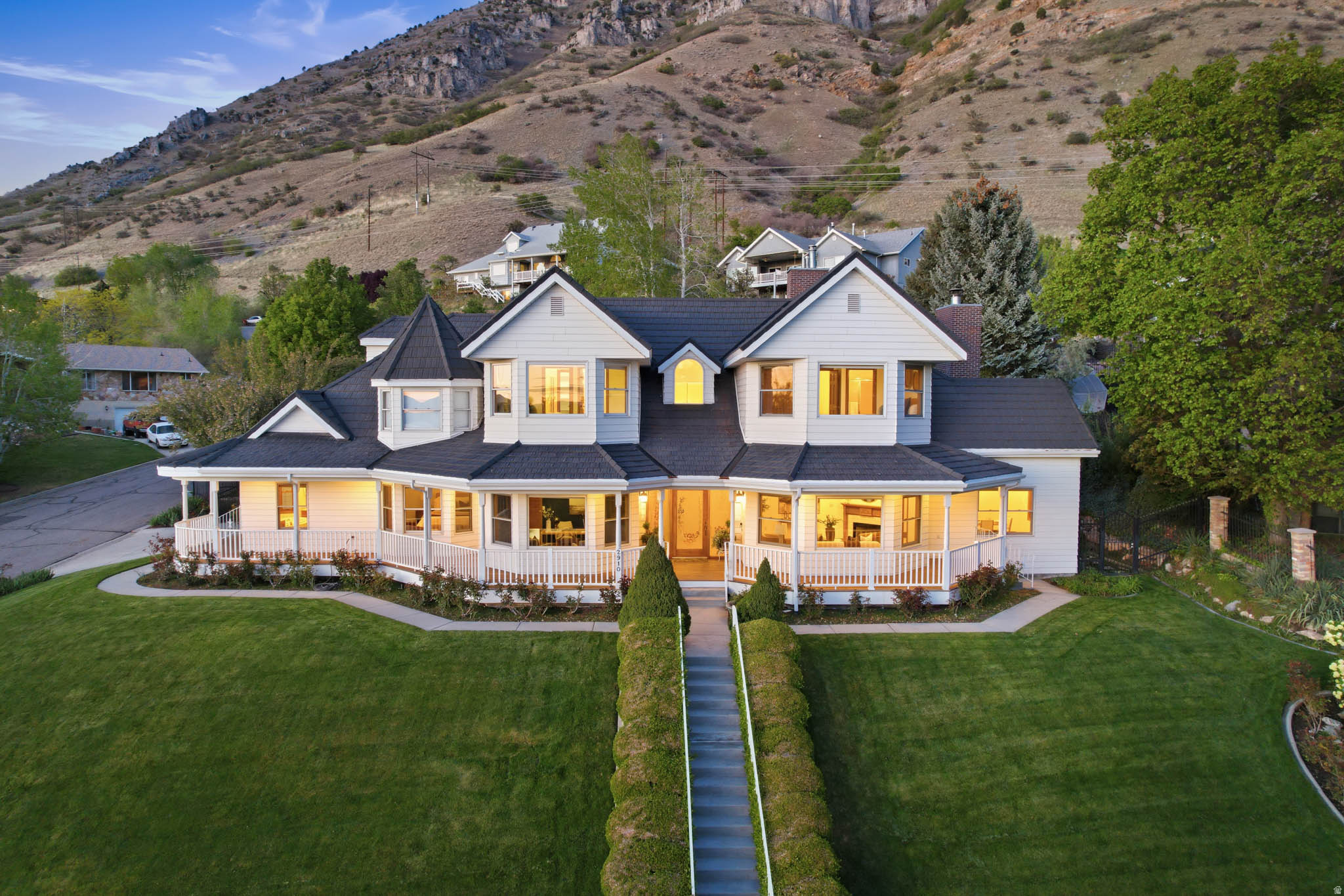 Perched on a quiet, scenic corner lot with breathtaking views of Utah Lake and the surrounding mountains, this exceptional residence blends timeless charm with refined luxury. From the moment you arrive, the inviting wrap-around front porch sets the tone, perfect for relaxing evenings and taking in the stunning sunsets and views of Utah Lake. Inside, you'll find a thoughtfully designed floor plan that balances elegance and functionality, featuring spacious gathering areas, multiple living spaces, and seamless flow ideal for both everyday living and entertaining. Rich woodwork throughout the home adds warmth and character, creating a sense of craftsmanship that is rarely found. Most bedrooms feature en suite bathrooms, offering comfort and privacy for family and guests alike. The gourmet kitchen is a true centerpiece, complete with high-end Bosch appliances, generous prep space, and a butler's pantry designed for both the culinary enthusiast and effortless hosting. Step outside to enjoy mature, lush landscaping that enhances the home's natural beauty and provides a private, serene setting. Whether you're hosting gatherings, enjoying quiet mornings, or simply taking in the views, this property offers a lifestyle that is both elevated and inviting. A rare combination of charm, craftsmanship, and breathtaking surroundings-this is a home you truly have to experience.
