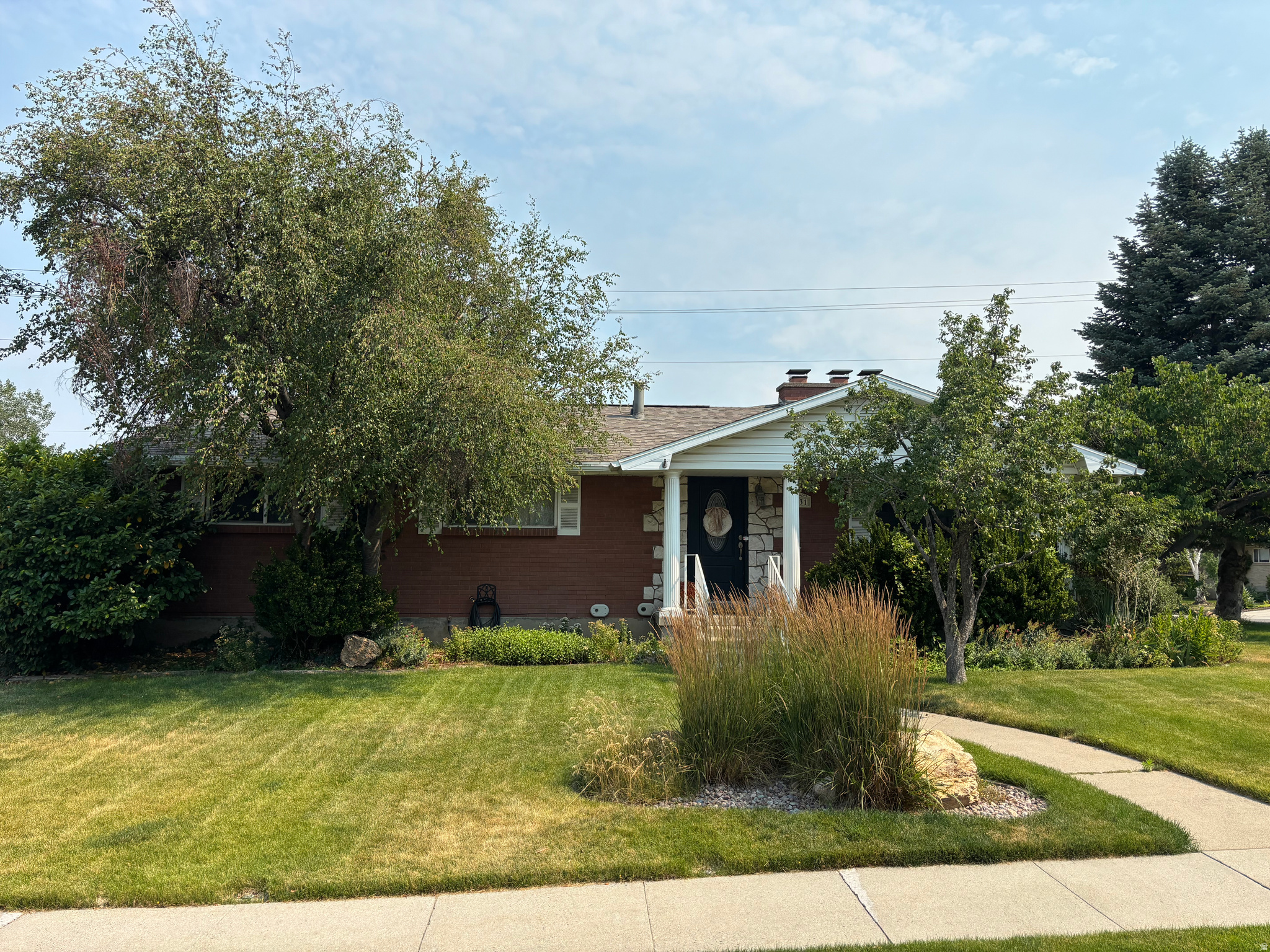 Charming brick rambler in a quiet Cottonwood Heights neighborhood with sweeping mountain views and minutes to Little and Big Cottonwood Canyons, shopping, and I215. Tastefully updated, this home sits on a spacious, fully landscaped lot with mature trees, a fully fenced backyard, and a twocar garage. The floor plan includes an elegant formal living room, a generous great room opening to a sunroom, and a large finished basement family room with a wet bar. The primary suite offers a private bath, and the home boasts many distinctive features: four fireplaces, a laundry chute, and extensive storage.