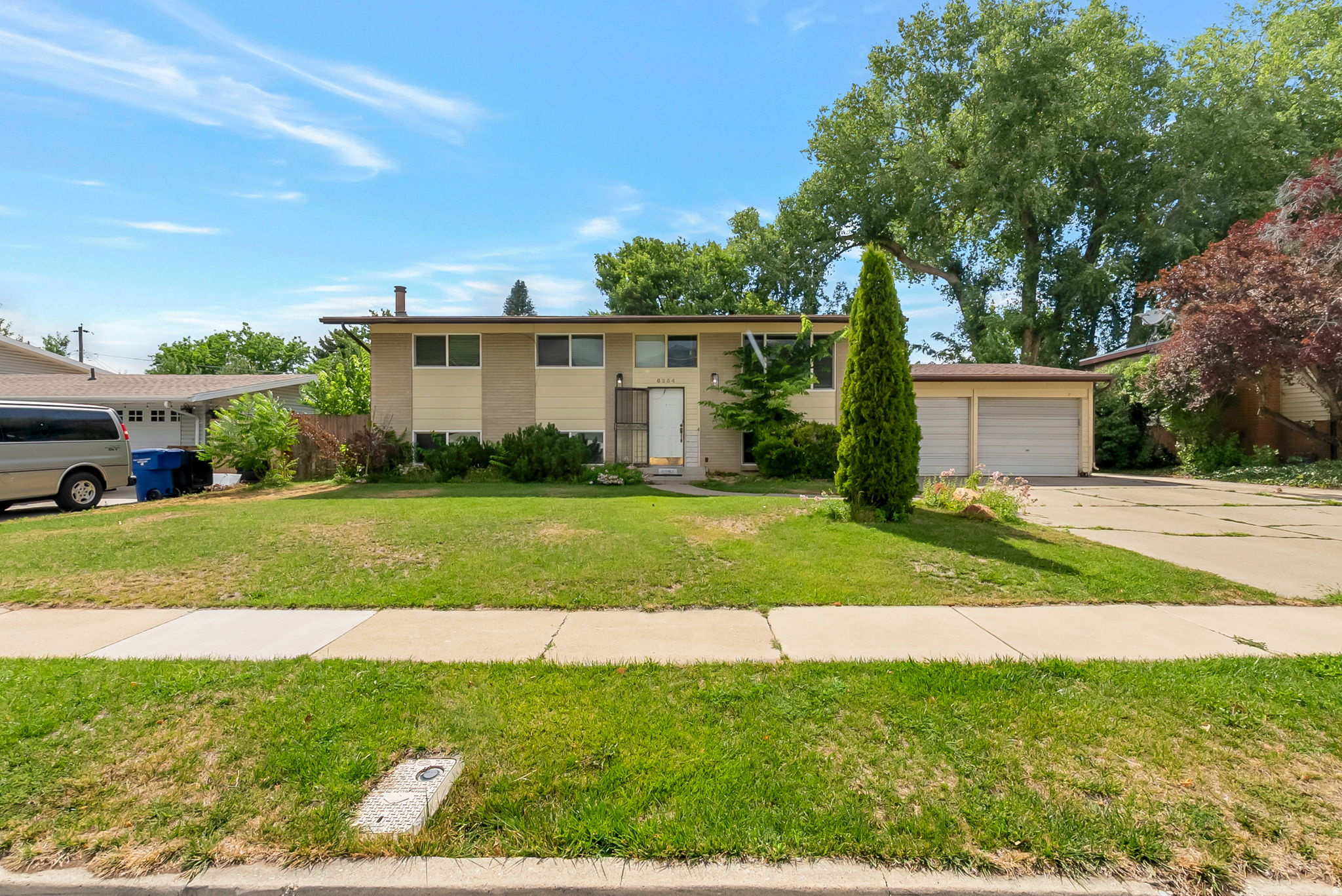 Located in the highly desirable Wasatch Village neighborhood of Murray, this beautiful 5-bedroom, 3-bath home offers the perfect blend of comfort, convenience, and Wasatch Mountain views. With 2,160 square feet of bright and inviting living space, the home features an open, light-filled floor plan, hardwood flooring, spacious living and gathering areas, and a fully finished daylight walkout basement with a separate entrance-providing exceptional flexibility for guests, a home office, or recreation space. Step outside and enjoy the beauty of Utah living from the covered deck and balcony overlooking the fully fenced backyard, complete with automatic sprinklers and ample space for entertaining, gardening, children, or pets. Additional features include central air conditioning, gas heat, abundant storage, and an attached 2-car garage. Ideally situated in a quiet, established neighborhood, this home provides easy access to top-rated schools, parks, shopping, dining, recreation, ski resorts, freeway access, and downtown Salt Lake City. Whether you're enjoying mountain sunsets from your deck or taking advantage of the nearby amenities, you'll appreciate the exceptional location and lifestyle this property offers. Move-in ready and filled with potential.
