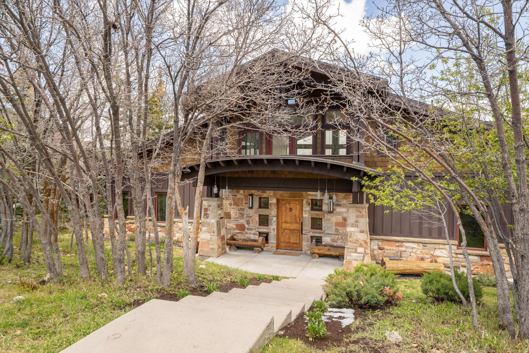 This timeless corner-lot home in the Aerie is fully move-in ready and ideally located just minutes from Park City's Main Street and world-class ski resorts. Positioned between Aerie Drive and Aerie Court, the property offers privacy, direct access to a nearby trailhead, and sweeping northeastern views.  Designed to capture bright light all year round--no matter the season--the home features soaring ceilings and expansive windows that fill every living space with natural light while framing stunning mountain vistas.  The open-concept floor plan is perfect for both everyday living and entertaining, with a spacious great room and a chef's kitchen complete with custom cabinetry, a Sub-Zero refrigerator, and a Wolf double range with dual ovens.  The main level includes a dedicated office and two bedrooms with ensuite bathrooms. The private northern wing serves as a true retreat, offering its own patio, two walk-in closets, a laundry area, and a generous spa-like bathroom.  Upstairs, guests and family will enjoy a separate living area that opens to an east-facing deck, along with two additional bedrooms, each with ensuite baths.  The lower level features a well-appointed mudroom with custom ski lockers, ideal for mountain living. An oversized three-car garage provides ample room for vehicles and includes additional storage space for all your recreational gear.