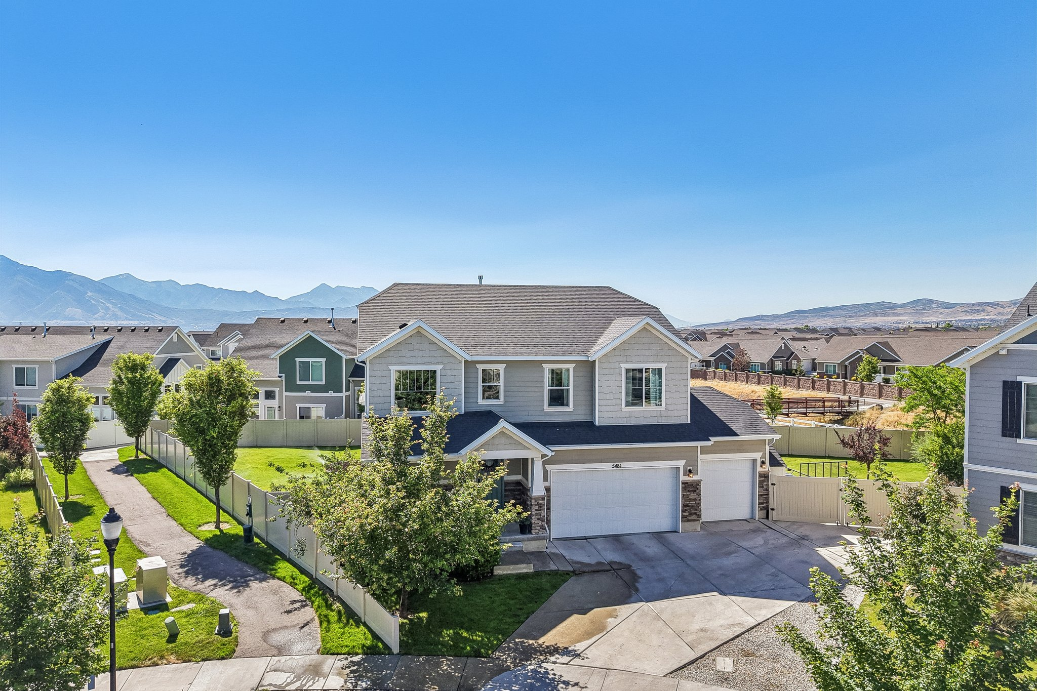 Rare corner-lot home on one of the largest lots in the neighborhood. Thoughtfully designed main floor seamlessly connects the gourmet kitchen, dining area, family room, patio, and hot tub. The chef's kitchen features quartz countertops, double ovens, an extra-large walk-in pantry, and a professional side-by-side refrigerator and freezer. The spacious family room offers a cozy fireplace, while the generous dining area provides plenty of room for gatherings. Upstairs, you'll find a versatile loft, three bedrooms, two full bathrooms, and a convenient laundry room. The primary suite includes a walk-in closet, double vanity, separate tub, and walk-in shower. Fully finished basement with a second kitchen, two bedrooms, full bathroom, second laundry area, and theater-ready setup with projector and surround sound wiring. Ideal for multi-generational living, guests, entertaining, or added flexibility. Enjoy a fully fenced and landscaped yard with portions bordering the Midas Creek Trail. The oversized three-car garage includes a Tesla charger and hot/cold water spigot. There's also gated RV parking with a double gate for easy access. Conveniently located near Mountain View Corridor, Mountain View Village, The District, shopping, dining, and entertainment. Built by Richmond American Homes, this popular Bedford floor plan offers the perfect combination of space, functionality, and location. Square footage provided as a courtesy from county records. Buyer and Buyer's Agent to verify all information.