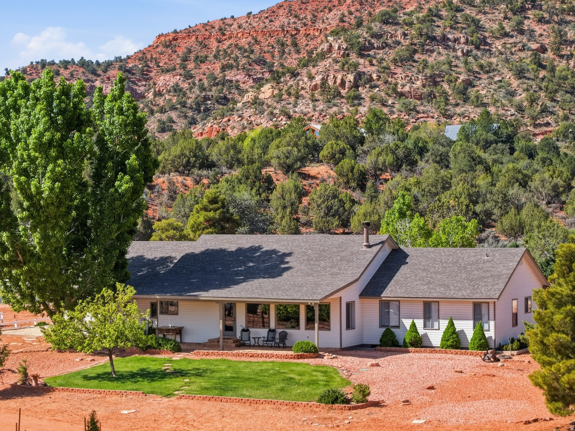 Welcome to this beautifully remodeled ranch-style retreat, thoughtfully reimagined to blend timeless charm with modern luxury. Set on 1.46 acres in a highly sought-after and established neighborhood, this exceptional property captures breathtaking red rock views from nearly every window. An inviting entryway welcomes you inside, where a private office with custom built-in bookcases offers the perfect space for working from home or quiet reflection. Vaulted ceilings draw you into the expansive great room, creating an open, light-filled atmosphere ideal for both everyday living and effortless entertaining. At the heart of the home, the brand-new chef's kitchen is designed to impress. Showcasing stunning granite countertops, a gas cooktop range, an oversized island with seating, a dedicated coffee bar, and a wine fridge, this space is perfectly equipped for gatherings of any size. A rustic beam accent and striking rock wood-burning fireplace anchor the living area, adding warmth and character-an inviting setting for cozy evenings. With five generously sized bedrooms, three well-appointed bathrooms, and an additional den ideal for a media room or secondary living space, the home offers exceptional flexibility to suit a variety of lifestyles. Short-term rentals are allowed, presenting a compelling investment opportunity as well. Outdoors features include mature trees, horse corrals, and thoughtfully designed landscaping enhance the natural beauty of the grounds. Unwind on the covered patio and take in the peaceful surroundings and stunning red rock vistas. Furnishings are available for purchase under a separate bill of sale, offering the potential for a seamless, turn-key transition. Buyer to verify.