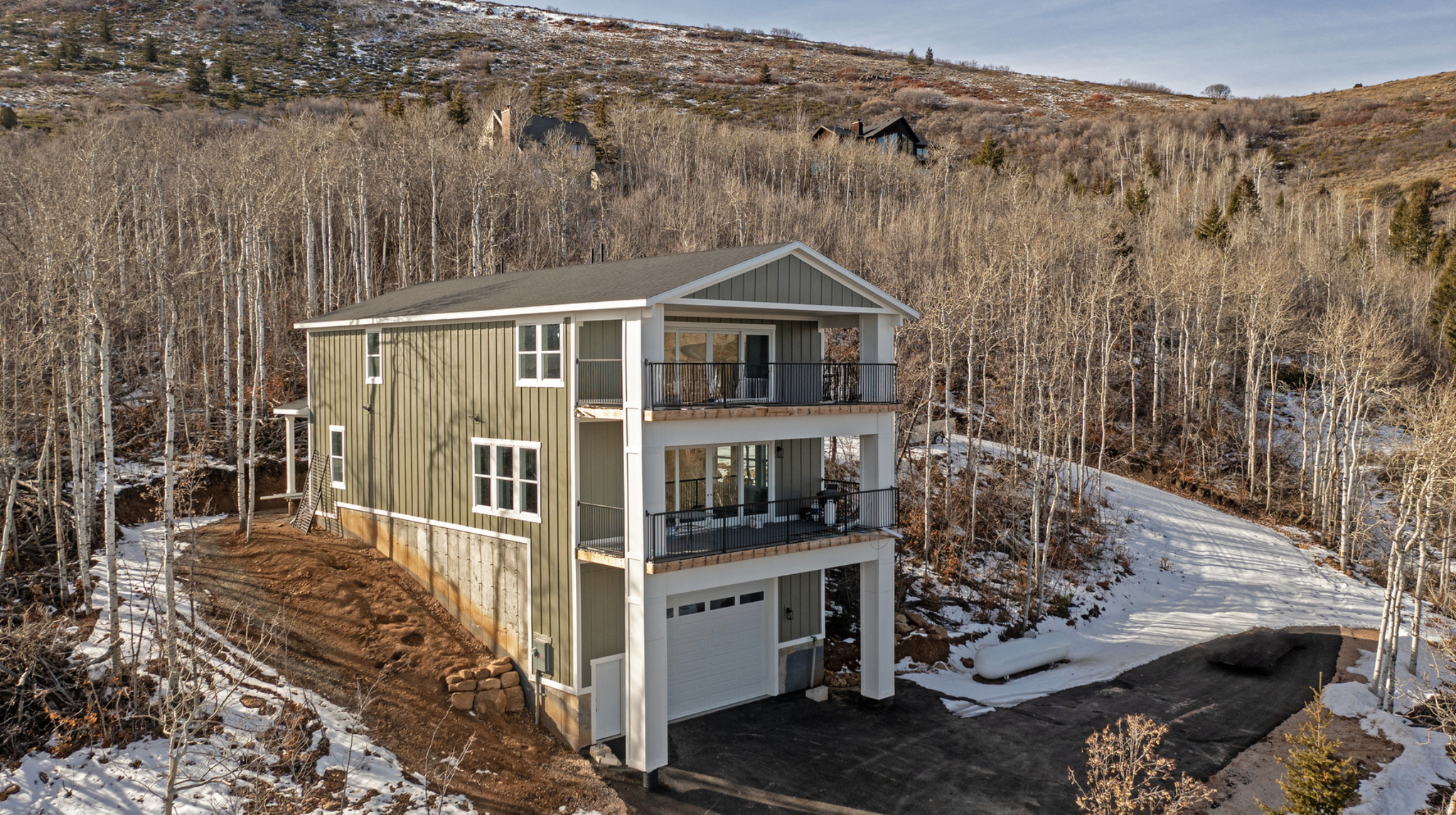 Tucked away in a wooded, private setting, this inviting Bear Lake home offers peaceful surroundings with beautiful lake views enjoyed from two covered balconies. The open kitchen, dining, and living area is designed for gathering, featuring a cozy fireplace and large view windows that frame the natural landscape. A main-level master suite provides comfort and convenience, while the upper level offers three additional bedrooms, a full bathroom, and a second living room with its own fireplace-perfect for relaxing or hosting guests. An extra-long, extra-high garage measuring approximately 30 by 40 feet includes an upper storage room of about 60 square feet, ideal for recreational gear and seasonal storage. The paved driveway and ample parking add ease and accessibility. Outdoor enthusiasts will appreciate the close proximity to The Sinks and Cache National Forest, offering direct access to ATV, UTV, and snowmobile trails, along with opportunities for snowshoeing, mountain biking, and hiking. Beaver Mountain Ski Resort is just 15 minutes away, while Bear Lake State Park Marina and Garden City are only 5 minutes from the property. Two nearby Garden City parks enhance the lifestyle, one featuring a scenic boardwalk to the beach and the other offering a fishing pond and pickleball courts. Please note that short-term rentals are not permitted by the HOA.