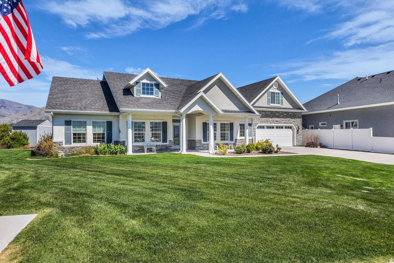 The buyer genuinely loved the home and was disappointed to back out of the purchase.  This home offers approximately 2,600 square feet of living space with four bedrooms, a den, and three and a half bathrooms situated on a lot of approximately 0.29 acres. Located in a desirable 55+ community, residents enjoy the convenience of exterior landscaping maintenance and snow removal included. The exterior features a spacious design with lush landscaping and inviting curb appeal, complemented by two covered patios and beautiful mountain views.  Entering the home, you are greeted by a spacious entryway that leads to an inviting layout filled with abundant natural light throughout. The main living area showcases an elegant fireplace feature, creating a warm and cozy atmosphere ideal for relaxing or entertaining.  The primary bedroom is generously sized and includes a spacious bathroom with ample vanity space. Additional bedrooms offer plush carpeting, while hardwood flooring in select areas adds warmth and character. Elegant lighting fixtures accentuate the home's refined aesthetic throughout.  A standout feature of the property is the climate-controlled bonus room located at the back of the garage, providing the perfect space for hobbies, projects, storage, or a private workspace.