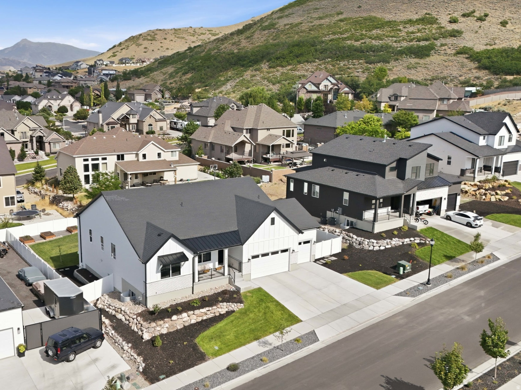 Properties of this caliber rarely hit the open market. Welcome to 14327 S Dennery Cove located breathtaking cul-de-sac in the highly desired Val Johnson subdivision. With the mountainside at your doorstep, this true trophy estate in Herriman featuring an unparalleled, fully finished aprx 1,900 sq. ft. ADU walkout basement that generates premium income or provides elite multi-generational living. Bypassing the exhausting delays of new construction, this 2023-built, 4,818 sq. ft. architectural masterpiece sits on a premium cul-de-sac and is delivered fully finished and meticulously landscaped. If you have the opportunity to secure this residence, consider yourself among the fortunate few. Showcasing striking high-contrast exterior design, you are welcomed by an elegant foyer flanked by an enclosed, dedicated home office with beautiful french doors-perfect for remote work. The sun-drenched, open-concept main floor flows effortlessly, featuring soaring vaulted ceilings, a gourmet chef's kitchen with elite quartz countertops, double wall ovens, farmhouse sink, gas countertop range, large pantry, and stunning backsplash and finishes. Enjoy the large living area, featuring a gas fireplace surrounded by herringbone tile. Step onto the expansive covered deck to experience premier indoor-outdoor living, perfectly framing panoramic mountain and valley views that offer breathtaking evening sunsets. The deck overlooks a fully fenced and beautifully landscaped, private backyard paradise equipped with a reinforced ground-level trampoline. The yard is boarded with beautiful garden beds and boxes that are connected to drop lines. Leading into the magnificent primary suite through french doors is a private sanctuary large enough for a seating lounge, tray ceiling, flowing seamlessly into a resort-style bathroom with dual vanity sinks, a large soaking tub, sleek frameless shower, and a massive custom walk-in closet. Two additional bedrooms, a full bath, and half bath complete the main floor. The absolute crown jewel of this estate is the incredible custom finished full-daylight walkout basement. Flooded with an abundance of natural light and soaring 10' ceilings this lower level completely defies the standard basement feel, truly living like its own independent home. It walks out directly to a private covered patio and the beautifully landscaped backyard. This dual-purpose powerhouse features a large wellness room complete with a private sauna that can be accessed from both those residing on the main floor or the accessory dwelling. Occupying the other wing is the independent ADU featuring two spacious bedrooms, a 3/4 bath finished with a beautifully custom tiled walk in shower, a second full kitchen, and its own private laundry room (washer and dryer included) and water heater. It stands as the ultimate asset for generating substantial rental income to effortlessly offset your mortgage. Beyond the impeccable property boundaries with its 3-car extra-deep and extra-wide garage and absolutely NO HOA fees, this home unlocks an elite Herriman lifestyle. For the outdoor enthusiast, this location is a dream! Offering unprecedented access to world-class recreation. You are mere minutes from W & M Butterfield Park, Cove Pond, Wide Hollow Trailhead (AKA The Stairs), Butterfield Trailhead Regional Park, Blackridge Reservoir, where you can spend your weekends relaxing on the sandy beaches, paddleboarding, or exploring the expanding Bonneville Shoreline Trail. You are perfectly positioned for endless entertainment and conveniences. Turn-key estates with this level of finish, income potential, and lifestyle access simply do not exist anywhere else. Do not miss your singular opportunity to claim Herriman's premier listing. Schedule your private showing today.  Square footage figures are provided as a courtesy estimate only and were obtained from the county records. Buyer and buyer agent is advised to verify all.