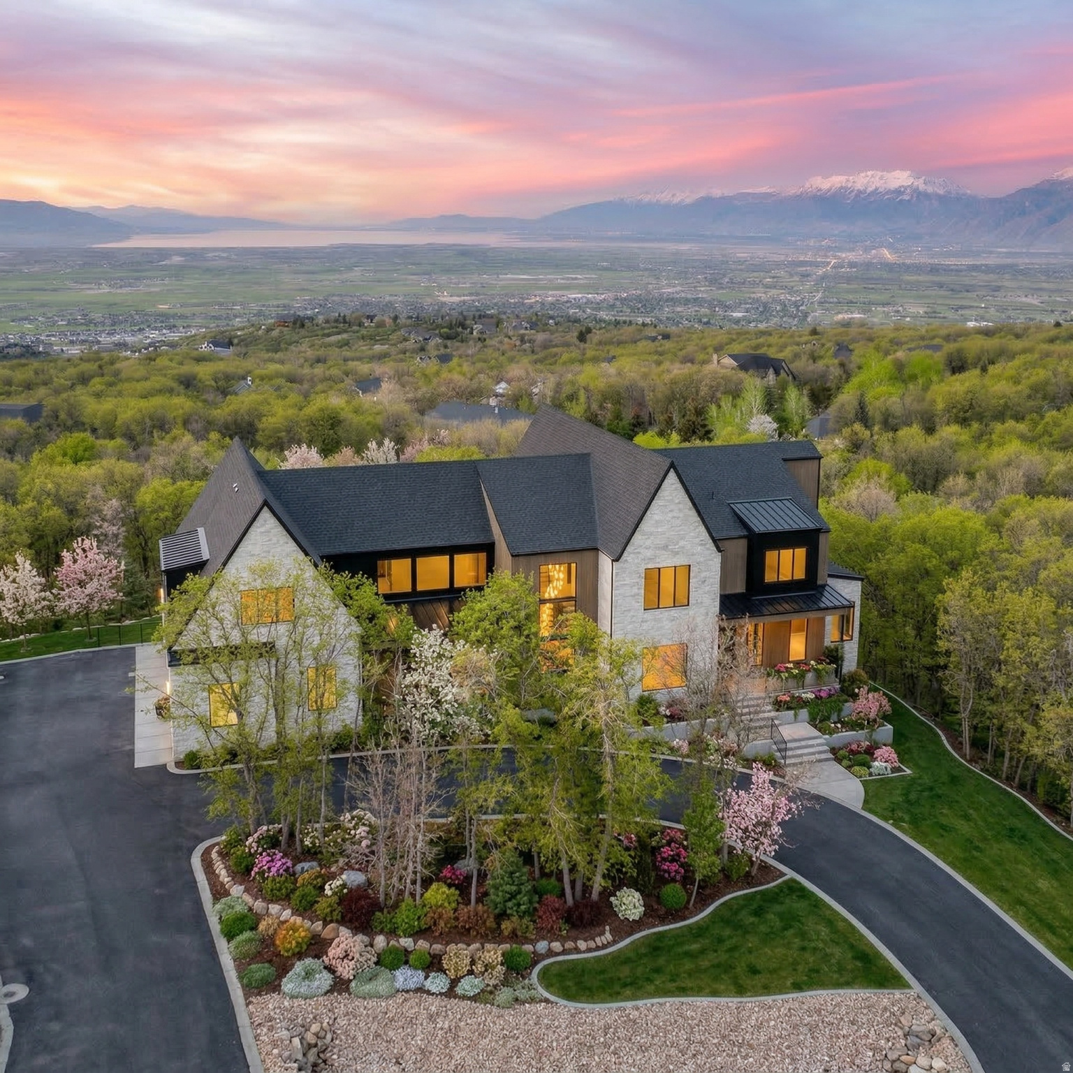 The Eagle Nest Estate | $4,795,000 - A brand new  Mountain Modern masterpiece in Woodland Hills showcasing breathtaking lake, valley, and mountain views. Thoughtfully designed for unforgettable entertaining and elevated everyday living, this 11,062 square foot residence delivers rare scale, craftsmanship, and lifestyle amenities in one of Utah County's most sought-after settings.  The main level features a grand great room anchored by a dramatic 22-foot stone/plaster fireplace, showpiece chandeliers, engineered European white oak flooring, and expansive sliding doors opening to a covered view deck that captures the entire valley. The chef's kitchen is extraordinary with Sub-Zero + designer grade appliances, a stunning 12' quartzite waterfall island, and a hidden pantry door leading to an impressive butler's pantry with floor-to-ceiling cabinetry, a second Sub-Zero refrigerator, pebble ice maker, sink, and dishwasher.  Retreat to a spa-worthy primary suite with a private view deck, a custom walk-in closet with its own laundry, and a serene bath featuring a decorative mineral plaster steam shower with dual heads + rain head, freestanding solid marble tub, bidet, makeup station, Taj Majal integrated sinks and other luxury finishes.   The upper level includes 5  additional bedrooms each with either an ensuite or a jack and Jill bath, a media/play room,  a study area, and a second laundry.   The walkout lower level is an entertainer's dream featuring a full second kitchen with a panel-ready Sub-Zero fridge and freezer, Patagonia quartzite countertops and backsplash, a theater room, workout room, 2 guest suites, and multiple covered outdoor living areas.  A true standout feature: a finished subterranean indoor sport court-a half basketball court with hoop plus pickleball lines and net-creating an unforgettable year-round lifestyle amenity.   Finished landscaping, a circular driveway, and abundant parking complete this exceptional offering.  The home was just completed  received Certificate of Occupancy on February 27, 2026. Schedule your private tour today.  All data, including all measurements and calculations of are, is obtained from various sources and has not been, and will not be verified by broker or MLS. All information should be independently reviewed and verified for accuracy.