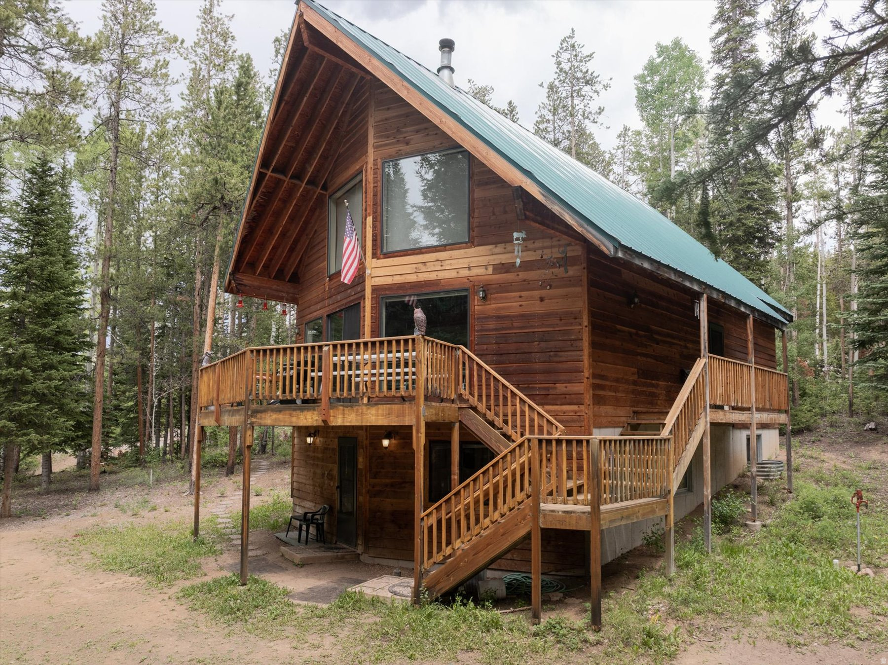 A slice of heaven, this cabin tucked away in the whispering pines offers an easy-to-access escape from busy lives and constant interruptions. Situated on a 3.37-acre parcel within the Uintalands gated community, this spacious oasis is a mere 60 to 90-minute drive from Salt Lake, depending on weather and traffic. In that short period of time, one can be transported into another world--a world filled with fresh, clean air, towering pines and Quaking Aspens as well as the opportunity to listen to the sounds of silence while savoring nature at its finest! This one-owner family cabin was lovingly constructed and designed to accommodate large gatherings or small intimate groups. As the location on Memory Lane implies, so many options abound for creating lasting memories. The main floor is open concept with room to gather, eat, play games or watch movies. Six bedrooms, two baths and a loft with a bunkhouse set-up that overlooks the great room provides a variety of sleeping arrangements. Added to that are the panoramic views from the two-story floor-to-ceiling windows in the great room and through the sliders out to the wrap deck. The ground level features a separate outside entry into the rec room with a pool table and four of the bedrooms and a bath. A "place for all seasons," there are any number activities to select from, including outdoor recreation to relaxing around the cozy wood-burning stove. Year-round water availability, underground power lines and Starlink internet expands the possibilities for working remotely, hanging out or just binge watching. Experience dark skies around one of the two approved concrete fire pits on the property. There is an incredible amount of privacy, as neighboring cabins are on equally-large lots yet, there is also a sense of community. Bring your toys, sports equipment, ATVs, bikes, fishing poles and imagination to take advantage of all of the community amenities. Those include a private fishing pond, a private archery/shooting range and access to ATV/biking/hiking trails to name a few. This property is more than a "cabin." It offers a lifestyle in a rustic environment with modern conveniences that is within driving distance at a moment's notice, even in winter. With the common area parking being plowed, owners can park trailers and access cabins via snowmobiles or tracked vehicles. The sellers have cleared the vegetation around the cabin to allow for ample parking as well as to assist with fire prevention. The cabin is turn-key property that comes furnished and ready for move-in. Some personal property and sentimental items to be excluded. Property details and square footage figures provided are deemed reliable; however, buyers and agents are encouraged to verify all. Short-term rentals are not allowed.