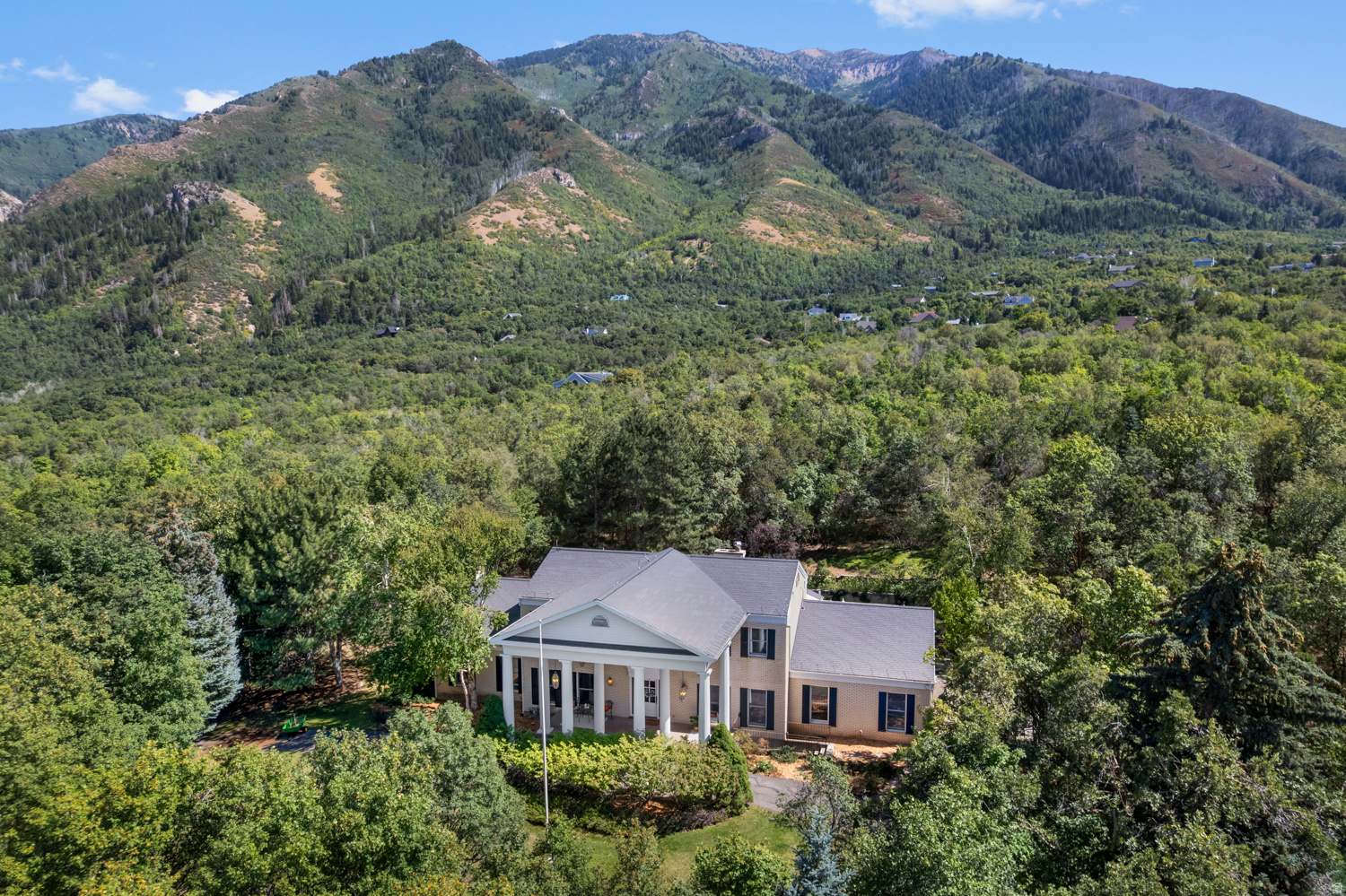 A rare Woodland Hills estate, nestled on five private acres, this fully remodeled and thoughtfully updated property offers a truly exceptional opportunity. Tucked along a quiet lane and surrounded by mature maple, oak, birch, and pine trees, the setting feels secluded and serene, yet remains just minutes from the conveniences of Spanish Fork and the heart of Utah County's most desirable communities. From the moment you arrive, the experience is unforgettable. The land itself invites exploration, with meandering walking and biking trails woven through peaceful forest scenery. Low-maintenance landscaping preserves the property's natural charm while allowing more time to simply enjoy it. Each season brings its own beauty, from fort building, camping, dirt biking in the summer, to having your own sledding hills in the winter as you sit and enjoy from your own front porch... and in the Spring, the season of the stunning Bigtooth Maple trees, if you wish, you can continue the unique option harvesting sap in February and March to create your own pure maple syrup. Frequent sightings of deer, wild turkeys, and other wildlife reinforce the feeling of living in a private retreat. This is a home that must be experienced in person-photos simply cannot capture the atmosphere or scale it deserves. Inside, timeless design and exceptional craftsmanship define every space. Solid white oak hardwood floors, custom moldings, coffered ceilings, marble flooring, and built-in living room cabinetry create a sense of enduring elegance. The chef's kitchen is a true centerpiece, featuring premium stone countertops, a professional-grade appliance suite, and an oversized refrigerator and freezer which is ideal for both everyday living and entertaining. Generously sized bedrooms provide comfort for all, while dedicated office spaces, a light-filled sunroom, and an inviting layout encourage you to slow down and stay awhile. The fully finished basement includes a complete kitchen and private entrance, offering endless possibilities for multigenerational living, an apartment, a home business, or an incredible entertaining space. With five bedrooms, five bathrooms, and a fully finished, impeccably organized garage, this home is as functional as it is beautiful. Thoughtful design and high-end finishes deliver both comfort and sophistication throughout. AH! And a brand new roof was just completed! The lot is subdividable, adding exceptional future potential. Known for sweeping mountain views, a peaceful atmosphere, and proximity to hiking, skiing, biking, and Utah Lake, Woodland Hills provides an unmatched lifestyle-and this property stands apart as something truly special. If you've been waiting for something remarkable, this is it. More than a home, it's a sanctuary, a lifestyle, and an opportunity like no other. Square footage figures are provided as a courtesy estimate only and were obtained from county records. Buyer is advised to obtain an independent measurement.