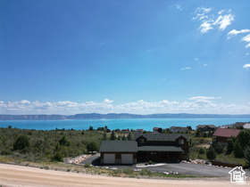 Price Reduced! Walk this homesite &  build your dream home tucked among the mature trees with sweeping views of Bear Lake. This gently sloping lot offers the perfect setting to preserve your forever lake view while providing privacy within the tree line. Property improvements are stubbed culinary water, sewer, and power. The lot has also been surveyed, with corners identified for your convenience. Enjoy the exceptional amenities of Bear Lake West, including owner access to Bear Lake, a 9-hole golf course with owner discounts, tennis & pickleball courts, & a heated outdoor swimming pool during the summer months. No short-term rentals are permitted, making this an ideal location for a peaceful vacation getaway or full-time residence. Now is the time to secure your place at Bear Lake.