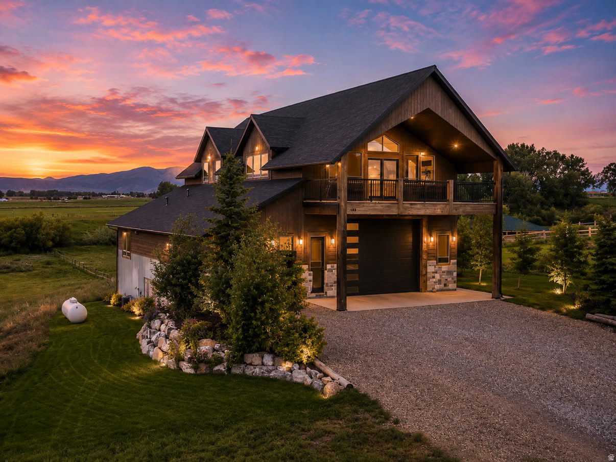 Perched atop a gently rolling hill and surrounded by sweeping mountain views in every direction, this custom-built home is a rare find. Nearly every window frames a postcard-worthy vista, while the 5.5-acre property offers serenity, space, and sustainability. A year-round stream flows peacefully alongside a scenic pond-perfect for enjoying quiet evenings and watching sunsets over the western range. Water rights for irrigation and a natural spring provide a sustainable, culinary-grade freshwater supply. Designed with both comfort and utility in mind, the lower level features an oversized 5-car garage-ideal for RVs, recreational toys, and workshop space. It's equipped with wiring for a mechanical lift and a 12+ foot high door for your largest vehicles. Upstairs, an expansive covered balcony invites you to start your mornings with sunrise coffee or unwind with evening grilling. Inside, rustic charm meets thoughtful design, with vaulted ceilings, a stunning stone fireplace, and walls clad in locally sourced, reclaimed barn wood. The spacious primary suite includes dual vanities, a walk-in shower, and a generous walk-in closet. The lower level also offers a full bath and a flexible office space-ideal for a guest suite, gym, hobby room, or lounge. A separate storage room with built-in shelving and a roll-up door provides ample space for outdoor gear and lawn equipment. Just 3 miles from the heart of picturesque Preston, Idaho and 23 miles to Logan, Utah, you'll enjoy the peace of country living with the convenience of nearby amenities. Several furnishings and key features convey, including a propane tank, water softener, sofa, kitchen table and chairs, barstools, and washer/dryer-making this move-in ready. This is more than a home-it's a lifestyle. Call the listing agent today to schedule your private tour of this one-of-a-kind sanctuary.