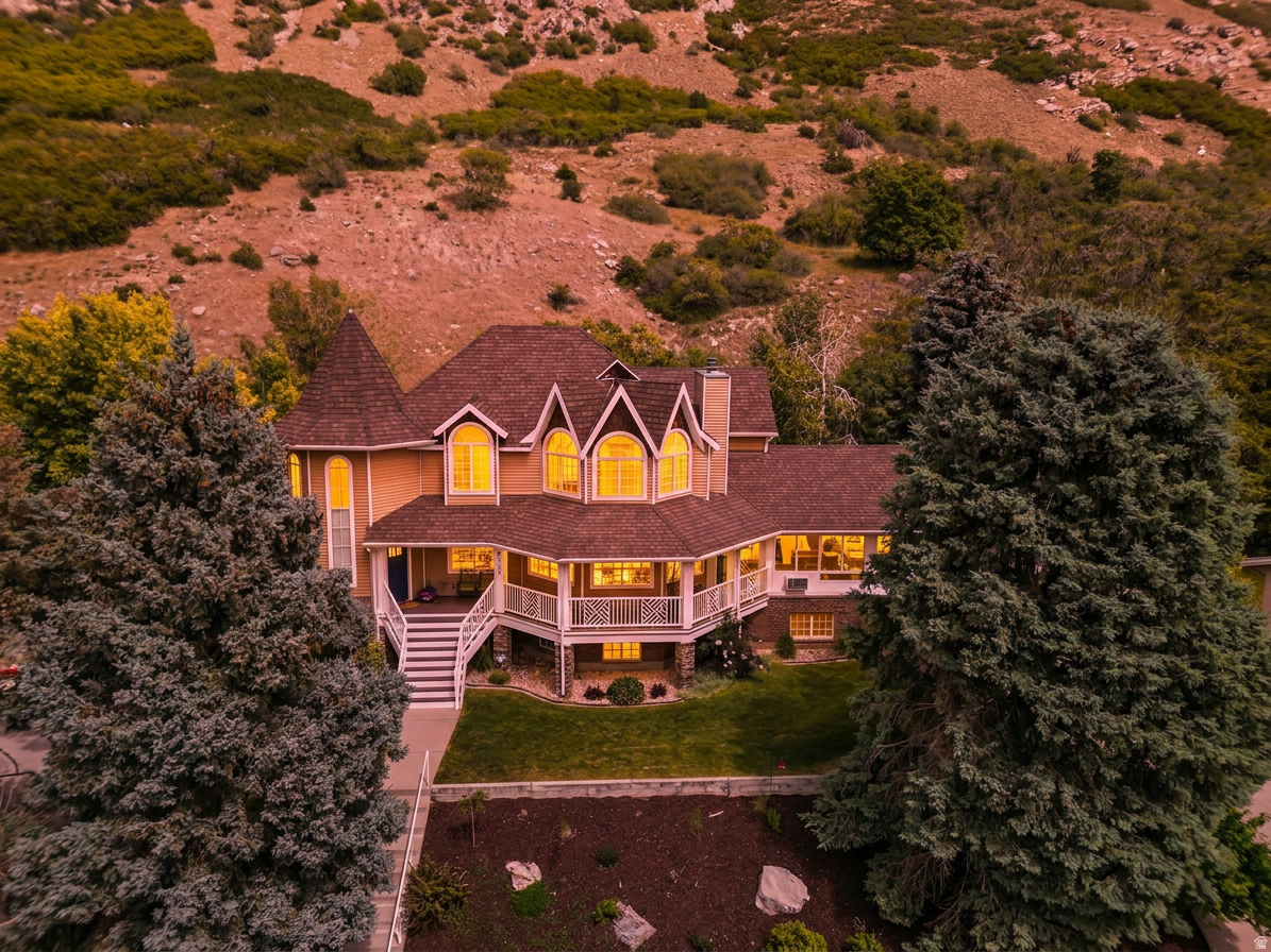 Some homes are beautiful. This one is unforgettable. Perched on Provo's coveted East Bench and backing directly to protected public mountain land, 4122 Imperial Way is a rare Victorian-style retreat where breathtaking views of Utah Lake and the Wasatch Range greet you from nearly every room. This is the kind of home you stop scrolling for - and once you walk through the door, you'll understand why. From the moment you arrive, the wraparound front deck sets the tone: a sweeping, peaceful perch above the valley where mornings feel slower and evenings feel earned. Whether you're sipping coffee at sunrise or watching the alpenglow fade over the mountains, this outdoor living space will become the heartbeat of your daily life. And because the home backs directly to protected mountain land, the wildlife comes to you - deer regularly wander into the backyard and have been known to settle in for a nap, while quail, bunnies, and the occasional wild turkey make regular appearances. It's a connection to nature you simply can't manufacture. Step inside to a floor plan that balances warmth and grandeur. The main-level living room features a stunning custom wood-burning fireplace - the kind that makes lazy Sundays feel luxurious and holiday gatherings feel truly special. Hardwood floors, plantation shutters, and a formal dining room set the stage, while the beautifully appointed den off the grand entry works equally well as a home office, library, or formal sitting room. The kitchen is the gathering place this home deserves - gorgeous Spanish tile, granite countertops, and a premium triple-filtered water system, all wrapped in natural light and views of the surrounding landscape. Above the garage, the sun-drenched sunroom is in a category of its own. Morning coffee spot, afternoon reading nook, quiet creative retreat - it's the room you'll find yourself gravitating to year-round. Upstairs, the primary suite feels like a private sanctuary. Vaulted ceilings, panoramic views of Utah Lake and the valley below, a generous walk-in closet, and a luxurious private shower combine to create a space that invites you to exhale at the end of every day. The second upstairs bathroom features a jetted spa tub perfectly positioned to soak in the mountain views - a rare luxury in any home, let alone one like this. The fully finished lower level is where this home truly separates itself. A dedicated media and theater room with blackout shades sets the stage for the best movie nights of your life. Multiple bedrooms offer flexible space for family, guests, or whatever your life requires - including a private guest suite with walk-in closet and luxury rainfall shower. The home gym provides serious, dedicated space to train, with a natural footprint perfectly sized for adding a sauna. And the oversized craft room and art studio - the kind of creative space people spend years wishing they had - rounds out a lower level that delivers something for everyone in the family. The location seals the deal. Top-rated schools including Canyon Crest Elementary and Timpview High are both within a mile. BYU is minutes away, and Provo Canyon puts world-class skiing, hiking, biking, and fishing practically at your doorstep. Homes like this don't come along often - Victorian character, modern luxury, wildlife-filled backyard, breathtaking views, and a lower level that works as hard as the rest of the home. This is not just a house. This is the life you've been looking for. Buyer to verify all listing information.
