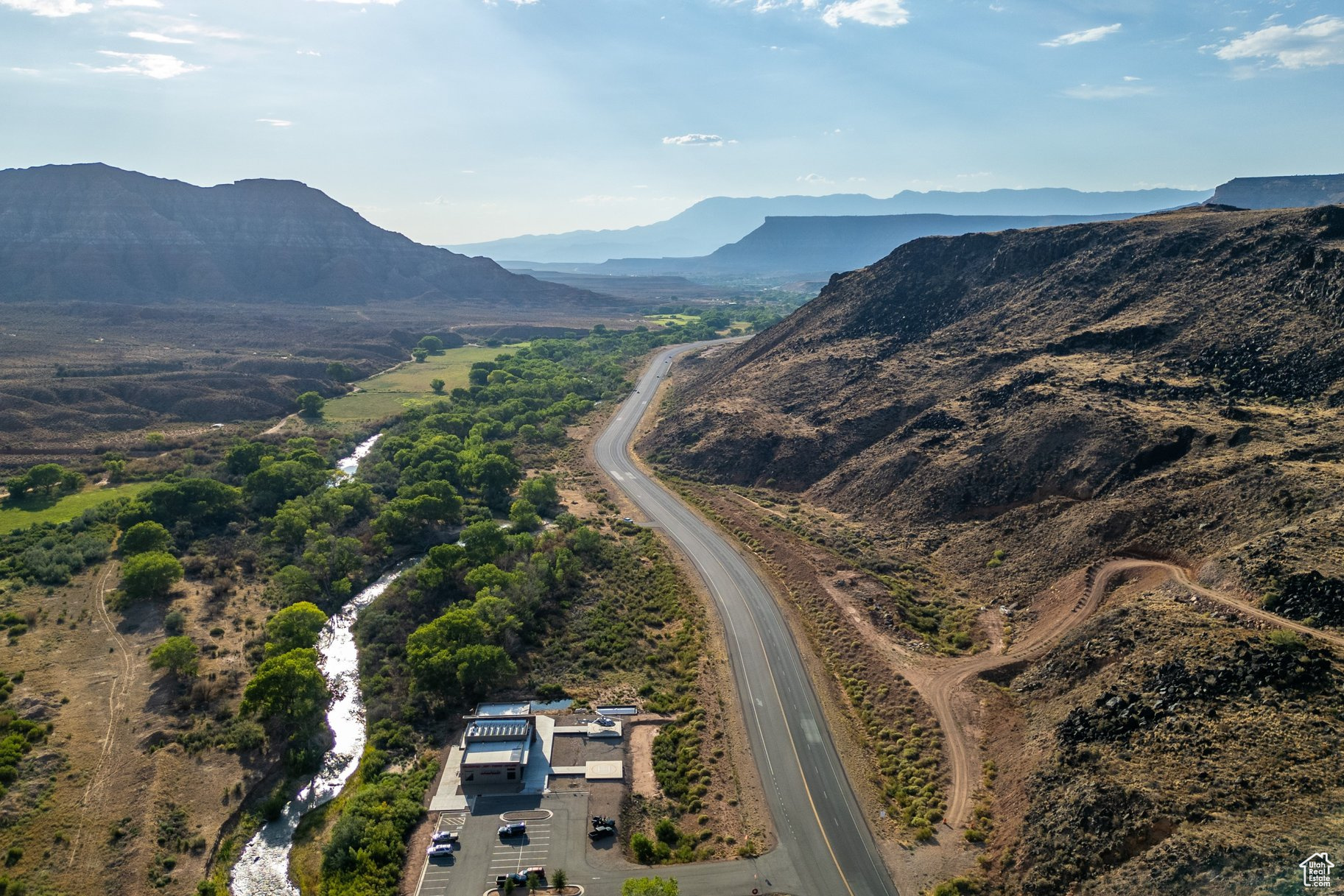 High Visibility opportunity with 2,755 linear ft of HWY frontage on both sides of SR-9 between Virgin and Rockville, including 2 Water Rights, on the way to Zion National Park. Washington County jurisdiction. Survey shows 3 possible building pads for a total of 4+ acres. Parcel includes Virgin River, flood plain and hillside. Located just west of Zion Helicopters.