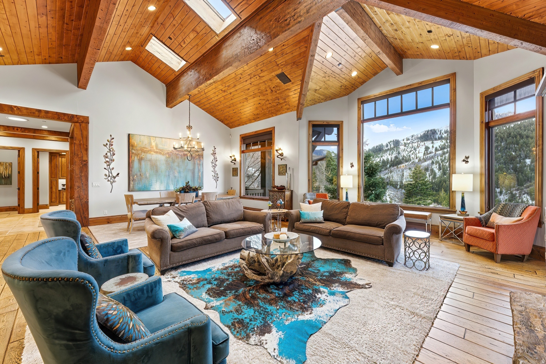 Located in the desirable Pineridge neighborhood, this mountain home offers sweeping mountain views of the Wasatch Mountain Ranges. Perched on over 1-acre, this 4-bedroom, 5 bath estate is the perfect home to take in the breathtaking surroundings. The open floor plan maximizes views from every room. The main living area opens up to an extensive deck to allow for wonderful indoor/ outdoor entertaining. Also located on the main level is the spacious primary suite with a large custom walk-in closet. The lower level has a large family room with fireplace, second kitchen and plenty of space for entertainment, along with three additional bedrooms. Additionally, there is an oversized three-car garage, with a workshop. The grounds of the home are stunning with mature landscaping and a fire pit.  The serene setting and abundant wildlife of the area are spectacular, providing the perfect tranquil retreat. Outdoor recreation can be found just outside your door with direct private access to hiking and biking trails. Begin enjoying your mountain retreat right away!