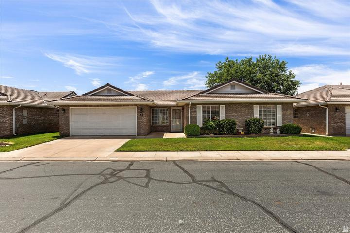 Welcome to Sun Country Meadows South, one of St. George's premier 55+ communities! This well-maintained single-level home offers 3 bedrooms, 2 bathrooms, and a 2-car garage with no stairs. Built in 1991 with quality brick construction and a durable tile roof, it features a comfortable floor plan and a primary suite with a walk-in shower. Enjoy exceptional community amenities including a clubhouse, indoor pool and hot tub, fitness center, billiards room, library, kitchen, dining and dance hall, family gathering areas, and a scenic pond with ducks. HOA is $240/month and includes water, sewer, garbage, private roads, partial yard maintenance, common area maintenance, and full access to amenities. Conveniently located near the hospital, shopping, dining, and everyday services.