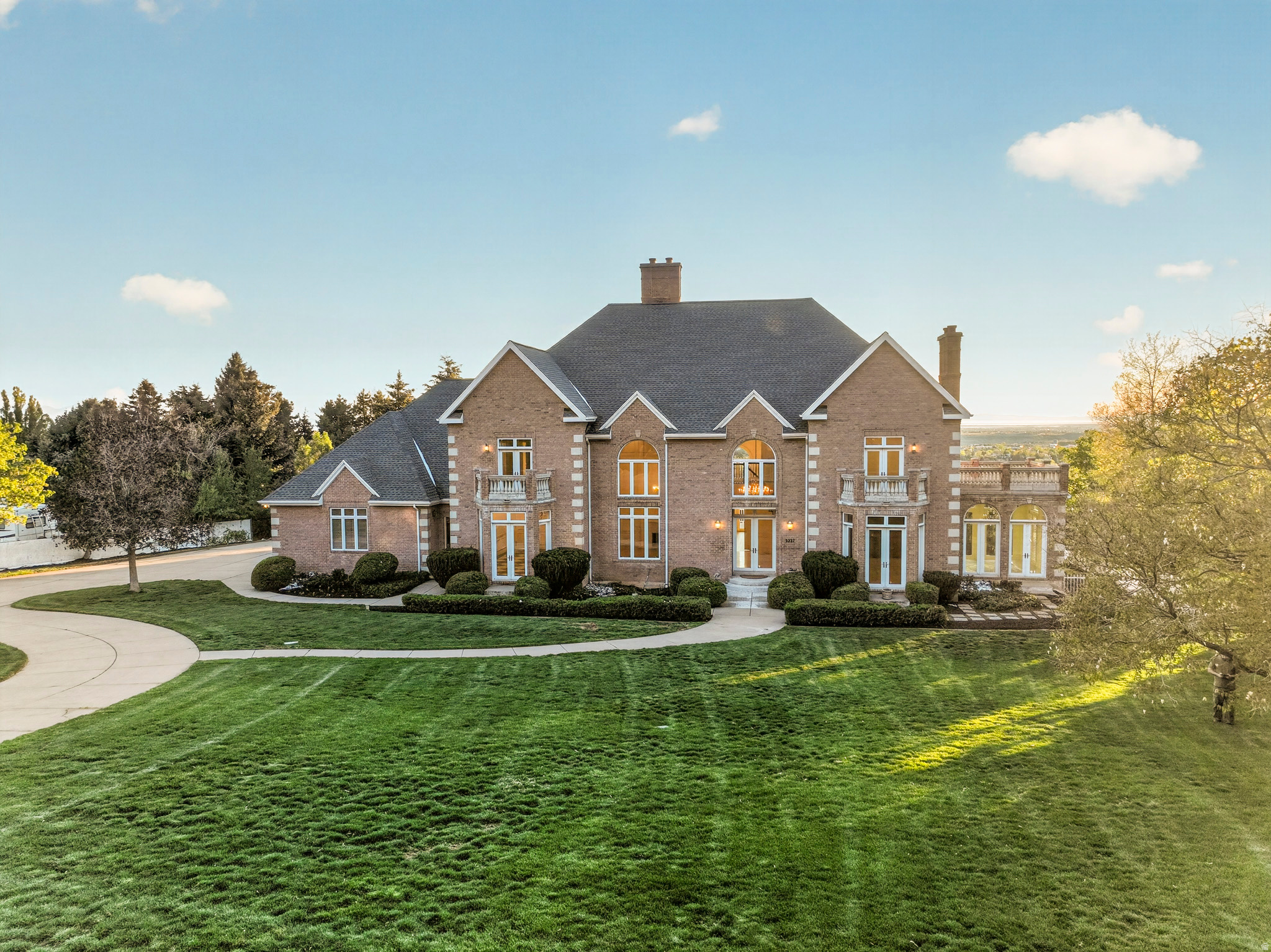 Exceptional custom estate crafted by Wilcox Construction set above Skyline Parkway on Ogden's coveted East Bench. Unobstructed sweeping panoramic views of the valley, Wasatch Front, and Great Salt Lake. Full-length windows on east and west elevations with remote motorized sun shades; Tray ceilings, hand-trimmed solid wood doors, 3/4" hardwood floors, Italian marble, adjustable LED lighting, custom cabinets and built-ins throughout add architectural distinction. Highlights include eleven chandeliers, 1,000 sq ft deck, Wolf and Sub-zero appliances, 20'x40' pool with in-ground spa, four gas fireplaces, main-floor primary suite, and en-suite bathooms in every bedroom. Mostly unfinished lower level exceeds 4,000 sq ft with 10-ft ceilings, partial framing and plumbing roughed in. Approx.  acre of undeveloped, buildable rear acreage offers significant expansion potential. Oversized 4-car garage. Recent capital improvements include: new roof, two AC units, 100-gal water heater, water softener, RO system, sewage ejector pump, Rachio smart irrigation controller, Pentair smart pool controller, Nest smart security cameras, thermostats, and smoke/CO detectors. Steps to Burch Creek Trailhead with direct trail access. Minutes to Weber State University and McKay-Dee Hospital. A rare caliber of offering on the Ogden bench. Assumable 2.25% interest rate or seller financing are options. Square footage figures are provided as a courtesy estimate only. Buyer is advised to obtain an independent measurement.