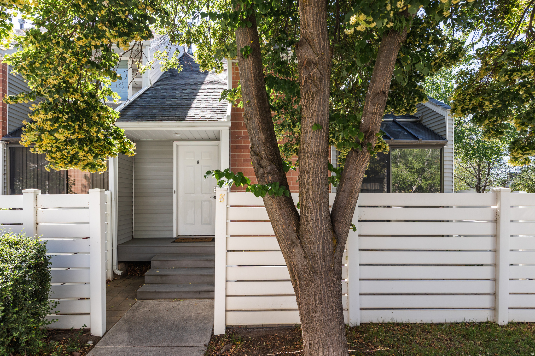 This is the kind of end-unit that doesn't come up often, and for good reason. Tucked into the Essex Community in Midvale, this roomy townhouse is shrouded in the kind of greenery that's likely to make you forget you're just a few minutes away from pretty much everything you need. One of our favorite features of the property, a large skylight in the living room sits above a sliding glass door that walks out to a private and shady patio with space enough to grill, eat, and relax, depending on your mood. Just adjacent, an exposed brick wall adds character to the space, and the open flow from there to the dining/kitchen keeps things feeling welcoming and breezy. Said kitchen has seen some recent updates that lend a bright and open feel. With three bedrooms here, there's plenty of room to grow, and each is generous in size (and there are just as many bathrooms, so no waiting on anyone else to get ready). The HOA is reasonable and takes care of the basics, plus you've got a dedicated laundry room and one less shared wall than most other units, being on the end. The attached, 2-car garage keeps it all convenient, and you're located just minutes from plenty of great spots to eat. All told, it's all here.