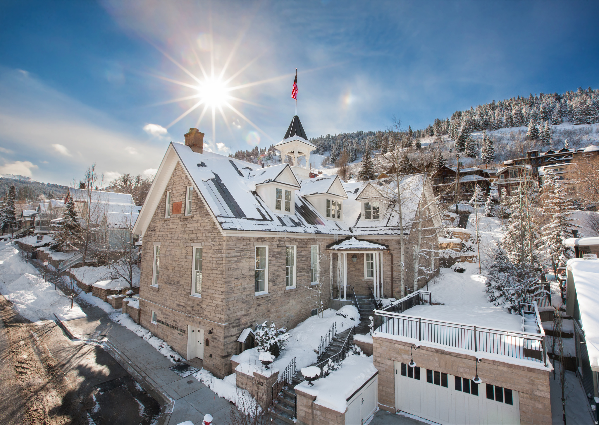The Washington School House is one of Park City's most iconic and irreplaceable properties. Built in 1889 as the city's first schoolhouse, this hand-carved limestone landmark now operates as a 12-room boutique property just one block from Main Street and 150 steps from ski access via Quit' N Time to the Town Lift.  Historically protected and prominently positioned, the property offers rare flexibility. Continue operating as a boutique hotel, convert to a private single-family residence, establish a private retreat, or pursue a hybrid approach blending personal use with hospitality. The top-floor penthouse, accessed by private elevator, functions as a premier guest suite while also accommodating discreet extended owner stays.  Grand living spaces anchored by a dramatic fireplace, curated ensuite accommodations, heated pool and spa terraces, and immediate access to dining, galleries, and year-round recreation define the experience.  With the 2034 Winter Olympics set to place Park City on a renewed global stage, ownership represents control of a Main Street, ski-accessible asset in a market where comparable historic holdings are exceedingly rare.  Main Street location. Ski access. Historic designation. Exceptional opportunity.