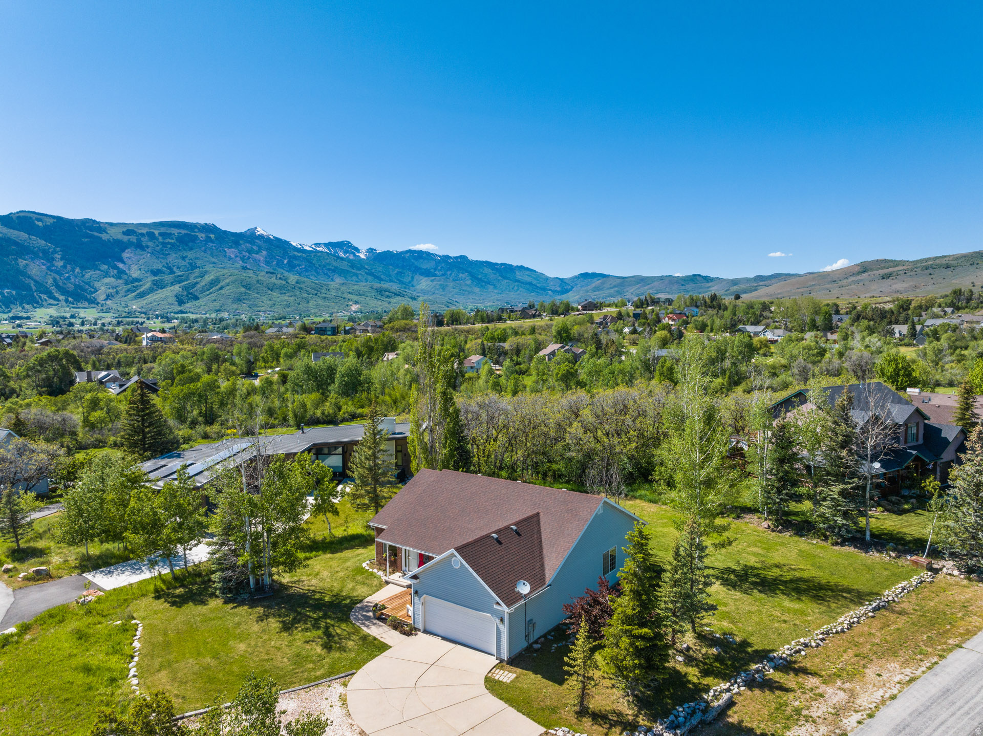 Perched against protected land with sweeping valley views, this exceptional home captures direct views of Pineview Reservoir and the iconic peaks of Snowbasin. Built for comfort and scenery, the property offers incredible outdoor living with excellent landscaping with mature trees. Inside, the home features a spacious kitchen and an excellent office that can also be used as a bedroom. The office comes with a custom desk, that gives one of the best office views in the area! Downstairs, you'll find a bright basement with a separate living area for entertaining or guest space. Large windows throughout the home bring in natural light and frame the stunning mountain and valley views from multiple angles. With a seamless blend of indoor comfort and outdoor beauty, this home offers a rare opportunity to enjoy mountain living at an attractive price point. The home sits just below the Wolf Creek Resort, and is less than 10-minutes from Powder Mountain, 20-minutes from Snowbasin, and centrally located to all the area has to offer.