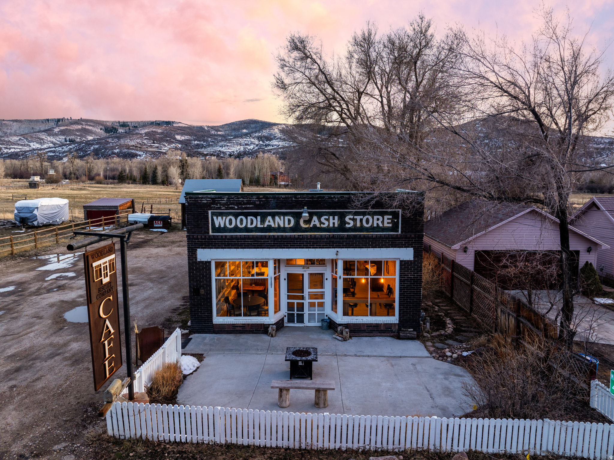 Well-maintained and full of character, this standalone commercial property offers a rare opportunity for a restaurant, cafe, event venue, or specialty food concept. Established in 1930 and operating as a cafe since 2015, the historic Woodland Cash Store enters a new chapter in 2025, continuing its legacy as a cherished community gathering place. The inviting storefront features classic brick construction, prominent signage, and excellent street presence, creating strong curb appeal and visibility.  Inside, the space opens to a warm and welcoming dining area with abundant natural light, polished concrete floors, and thoughtful finishes throughout. The flexible layout comfortably accommodates multiple seating arrangements, making it ideal for dine-in service, private events, or experiential retail use. Tasteful built-ins and dcor preserve the building's historic charm while maintaining a clean, professional aesthetic.  The commercial kitchen is fully equipped with stainless steel appliances, vent hood, gas range, prep space, and ample storage-designed for efficient workflow and ready for immediate operation.  Dishwasher is leased currently. Whether you're an owner-operator or investor, this turnkey property offers both functionality and atmosphere, providing a unique opportunity to operate within a space rooted in history while supporting modern commercial use. All property information, boundaries and documents to be verified by buyer.