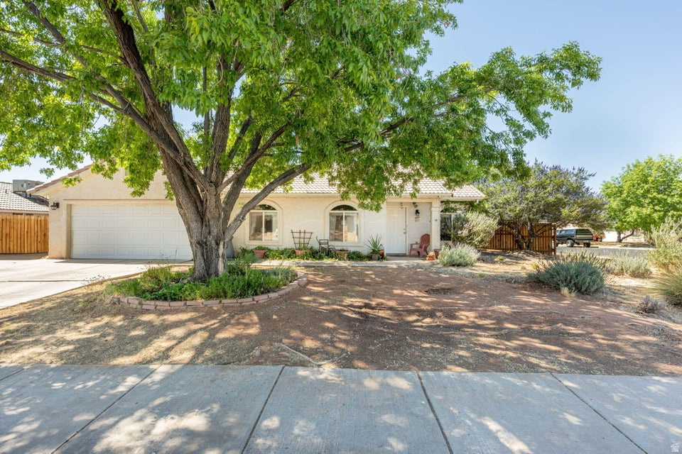 Welcome to this charming single-story home in a central location with no HOA. Nestled on a generous .18-acre corner lot with 3-bedrooms, 2-bathrooms and a 2-car garage. Step inside to find a warm and comfortable living room with vaulted ceilings and arched doorways. The kitchen offers abundant oak cabinetry, stainless steel appliances, tile floors and a convenient breakfast bar, plus access to the backyard. Outside you will love the fully fenced yard with mature trees, grass, raised garden beds and a fully automatic sprinkler system. Solar panels add incredible energy savings year-round, keeping those utility bills low during the summer months. Located perfectly between Sandstone and Panorama Elementary schools, and just minutes from Costco, Dinosaur Crossing shopping and all the dining and recreation Southern Utah has to offer.