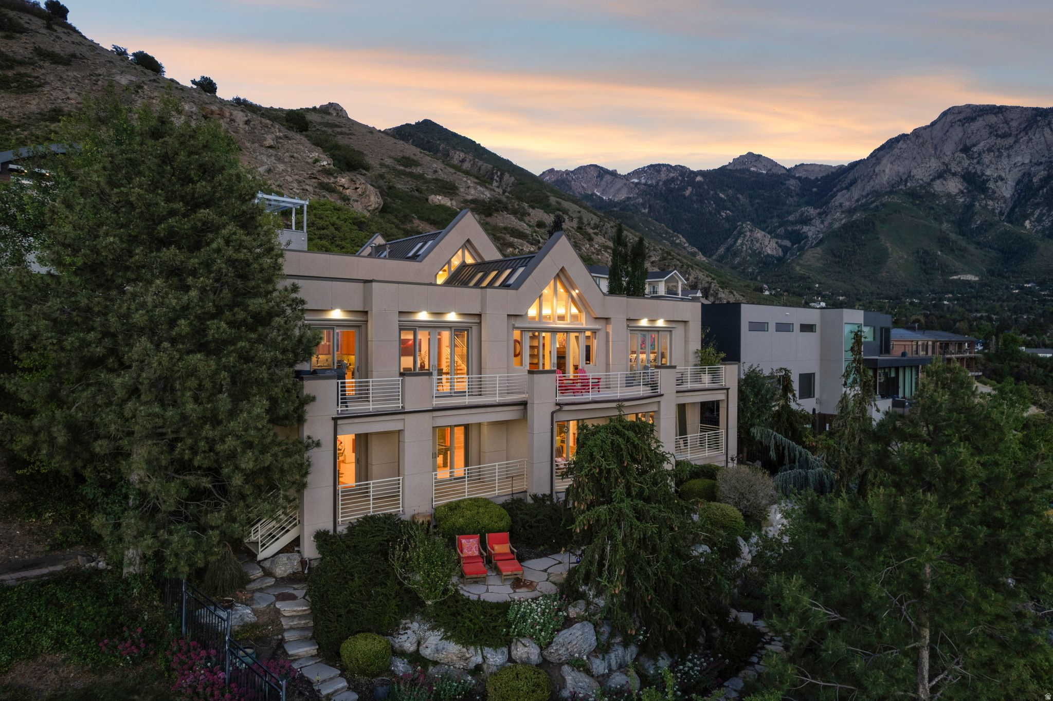 Perched in the heart of Millcreek, this stunning contemporary residence at 3660 S. Choke Cherry offers an exceptional blend of modern design, comfort, and breathtaking scenery. Set on a generous .24-acre lot, the home showcases sweeping, unobstructed panoramic views of the entire Salt Lake Valley, with iconic vistas of Mount Olympus serving as a dramatic daily backdrop.  Step inside and discover an open, light-filled great room highlighted by soaring floor-to-ceiling windows that perfectly frame the surrounding landscape. The thoughtfully designed main level features a private office, skylights that flood the home with natural light, and a warm, inviting gas fireplace. The high-end kitchen is both functional and elegant, complete with premium cabinetry, granite countertops, top-tier appliances, and undercounter lighting-ideal for both everyday living and entertaining.  The spacious main-floor master suite is a true retreat, offering incredible views, a beautifully updated bathroom with dual vanities and a sleek glass countertop, a separate tub and shower, and walk-in closet. Neutral tones and newer blinds throughout the home create a clean, timeless aesthetic.  The lower level expands the living space with a large family room, a second kitchen, workout room, an additional gas fireplace, two more bedrooms, and a walkout basement. A gaming area and access to a private lower patio make this level perfect for guests or multi-generational living. You'll also find a well-appointed laundry room, a workout space (universal weight set machine and free weight set included), and abundant storage on the mid-level.  Outdoor living is just as impressive, with two expansive decks spanning the length of the home-perfect for taking in unforgettable sunset views. The fully fenced backyard offers privacy and space to relax, while the heated driveway, courtyard entry, and spacious two-car garage add convenience and year-round comfort.  Ideally located near top-rated schools, shopping, and downtown Salt Lake City, this home also places you just minutes from world-class skiing and outdoor recreation. A rare opportunity to own a view property that truly has it all.