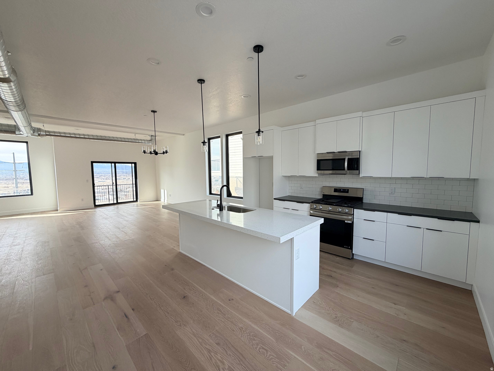 Amazing Views! New Modern East Bench Draper Townhouse.   Sleek contemporary exterior complemented by a 2-car garage. Open-concept living area bathed in natural light, large windows and strategic placement that frame breathtaking panoramic sunset views over the valley and mountains. The well proportioned living spaces flow seamlessly, ideal for both relaxed family time and sophisticated entertaining. Downstairs, a secluded en suite bedroom in the basement provides a private retreat with its own luxurious bathroom and ample space for relaxation or the perfect home office.