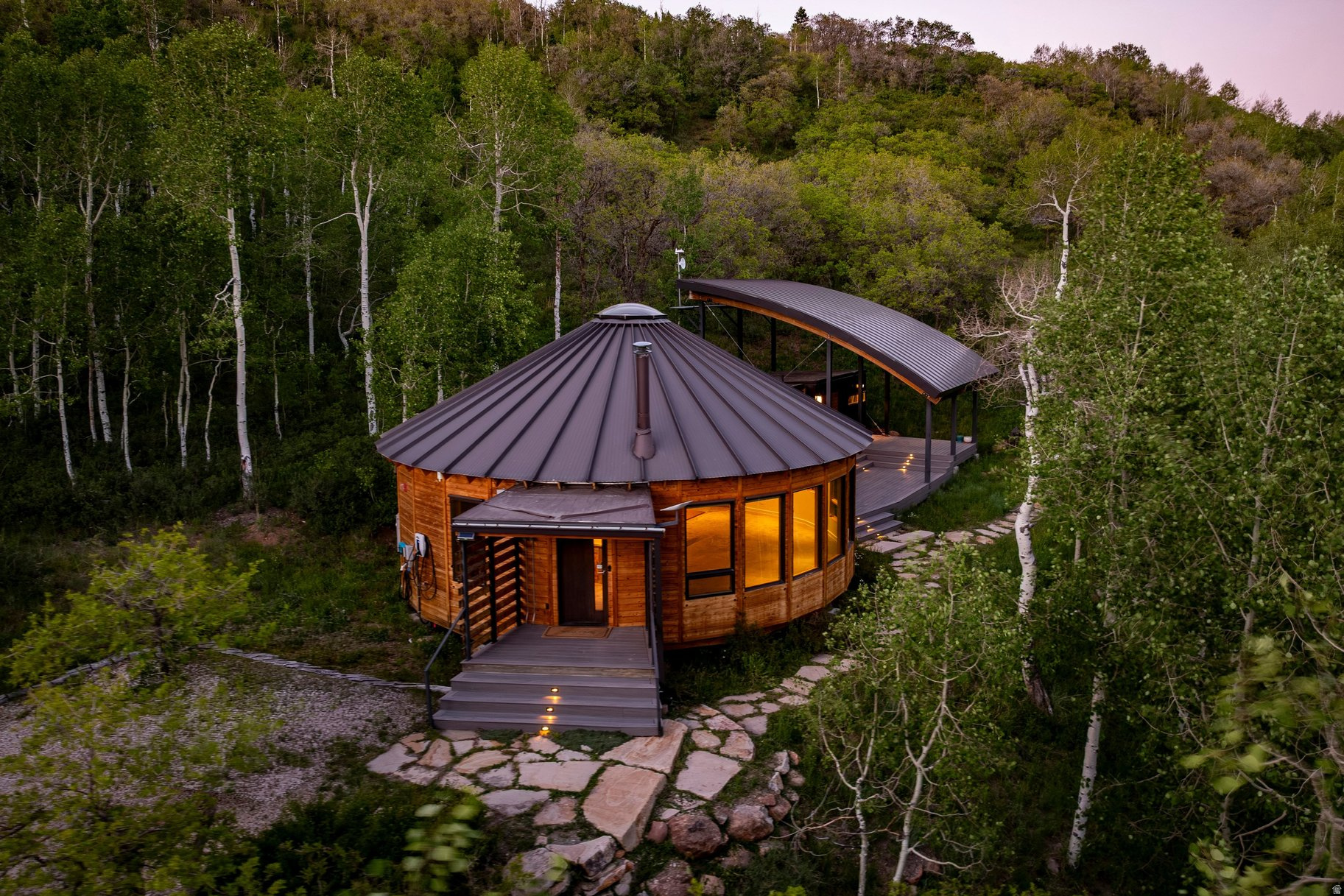 Rare opportunity to own one of the premier estate lots in Stagecoach Estates. Spanning 11.75 acres within a mature aspen forest, this remarkable homesite offers exceptional privacy, and sweeping, unobstructed views of Park City Mountain and Deer Valley. A level driveway provides convenient year round access, making four season mountain living effortless. At its heart is a striking, architecturally distinctive yurt that lives larger than expected. Soaring ceilings radiate from a central circular opening, and a dramatic curved wall of windows wraps the main living space, creating the experience of living inside an aspen forest. Custom geothermal heating system, radiant in floor heat, triple pane windows, and a wood burning stove give the interior a refined, grounded warmth. Concrete floors, a reclaimed wood kitchen island, high end appliances, and a glass shower that frames the forest. Stagecoach Estates allows for up to three structures per lot, giving you ample room to construct a primary residence. Whether used as an immediate mountain retreat, or basecamp while building your dream home, the yurt provides year round comfort and functionality.   The HOA is paving Basin Canyon Road beginning in summer of 2026, and the property sits within the highly sought after Park City School District.  A truly one of a kind chance to create a mountain estate in one of Park City's most scenic and secluded settings.