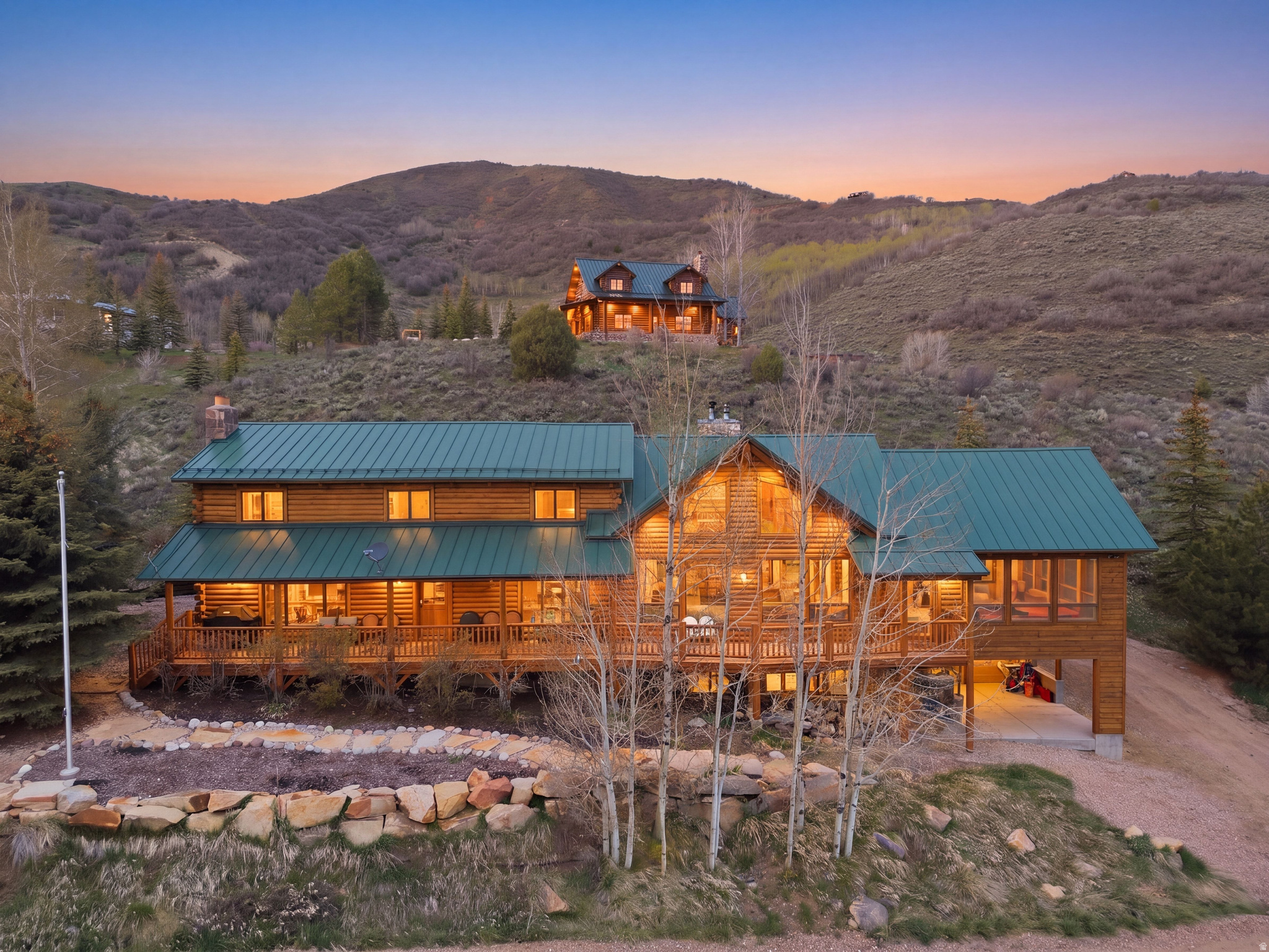 Gated and private, this Weber Canyon log cabin sits on two parcels totaling over two acres with sweeping mountain and valley views stretching down to the Weber River. Located within a gated community, Weber River access makes this a rare find for fishing, kayaking, or simply enjoying the water. The main parcel features a beautifully crafted full-log home with vaulted ceilings, multiple stone fireplaces, a fully finished walkout basement, and wraparound decks that frame the scenery from every angle. The second parcel includes a large red barn with garage bays, ideal for equipment, toys, or a workshop. Year-round paved access via Weber Canyon Road means you're never locked out by the seasons, yet fully removed from the noise of everyday life. Less than an hour from Salt Lake City and a short drive to Park City, this is mountain living without compromise.