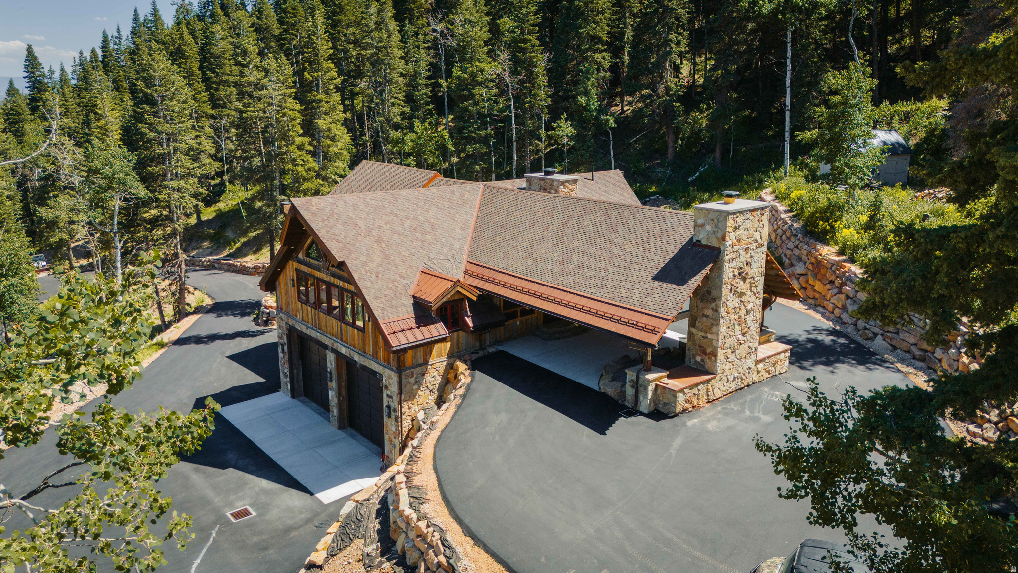Experience refined mountain living at Mountain Air, an exquisite 5-bedroom, 7-bath estate with a loft, office, and dedicated theater room spanning over 5,400 sq ft across two parcels totaling 7.77 acres. Located just 20 minutes from Park City's Main Street, the property offers year-round access and a newly paved private driveway with a gated entrance. Each bedroom is a private ensuite, designed for both comfort and privacy when hosting family and friends. The home was thoughtfully crafted with reclaimed materials, including 100-year-old structural trusses and hardwood floors sourced from a dismantled tobacco barn. The chef's kitchen features custom maple cabinetry, Viking and Thermador appliances, and opens to a spacious covered outdoor BBQ area with a wood-burning fireplace. Additional features include an oversized garage, elevator, media room, multi-zoned smart HVAC system, and tree-lined trails that lead to your own private hilltop with panoramic views of the Uinta Mountains. Recent 2025 upgrades include a fully paved driveway, private gate, engineered retaining walls and drainage system, upgraded heat tape, a wildlife/retention pond, and prep work for a future detached garage. The second lot is fully improved with power, water, and a ready-to-build homesite, offering flexibility and long-term value.