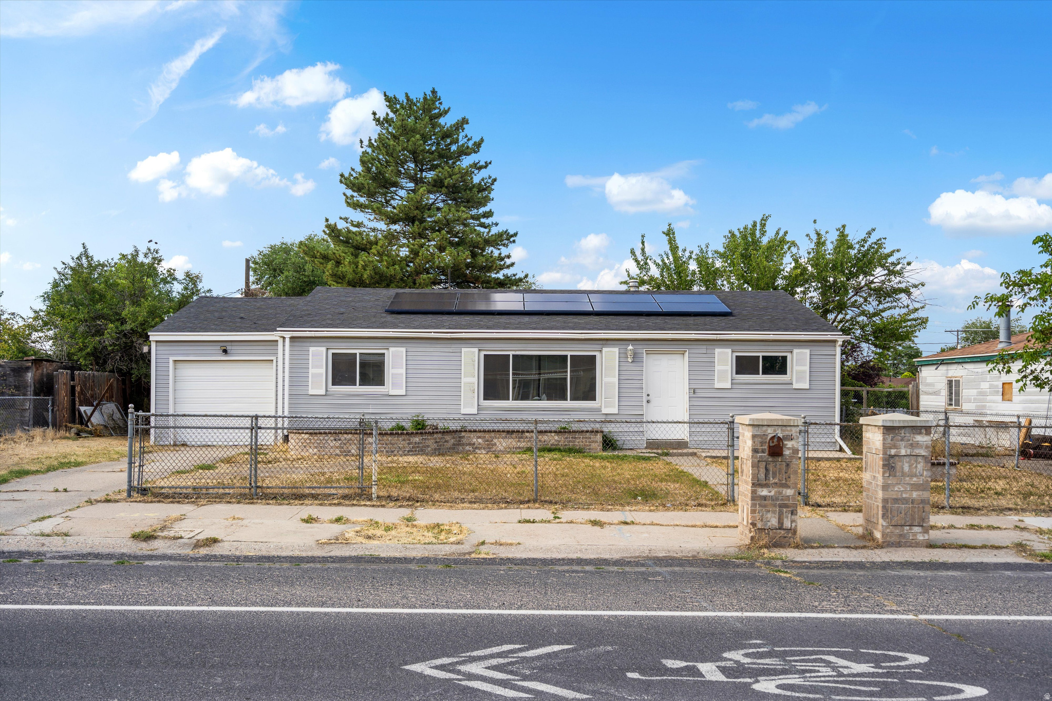 Welcome to this home in the heart of Kearns! The layout offers three bedrooms, two bathrooms, and convenient main-level laundry. Enjoy an attached garage, fully fenced yard, mature shade trees, backyard patio space, and an outdoor brick fireplace area with room to make the yard your own. Paid-off solar panels help keep utility costs low-seller's highest monthly power bill was approximately $70 in September, with most other months around $15$20. Major updates include A/C and furnace replaced in 2019 and a water heater replaced approximately 2 years ago. Vivint smart home system is included with doorbell and outdoor cameras. Convenient location near highways, shopping, dining, entertainment, and Bruce Field Park just a 1-minute walk away. Gourley Elementary is around the corner, with Kearns Jr. High and Kearns High less than 1.5 miles away.
